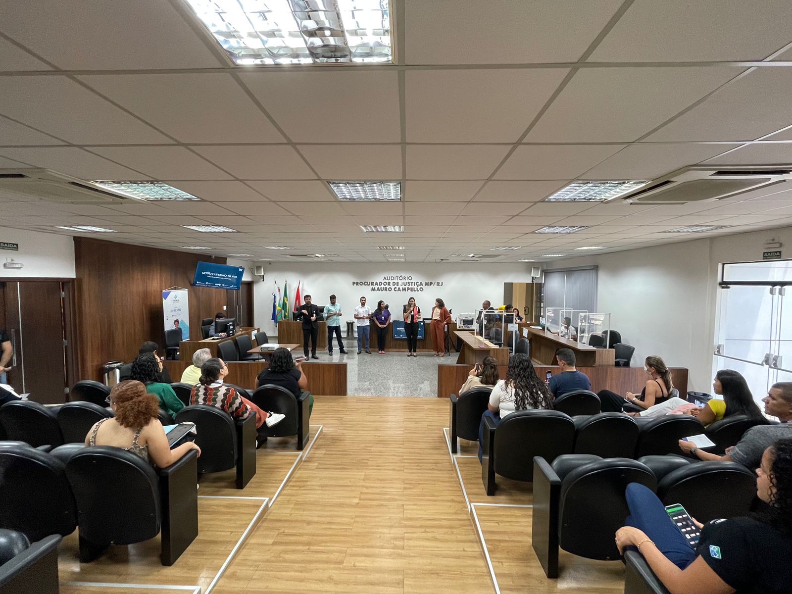 foto colorida mostra pessoas reunidas no Auditório Procurador de Justiça MP/RJ Mauro Campello, do Fórum Criminal Ministro Evandro Lins e Silva do TJRR,  enquanto o  Secretário de Comunicação do Estado de Roraima, Weber Negreiros, ministra palestra e o tradutor de libras ao lado,  durante “Ação Cuidando do Servidor”. 