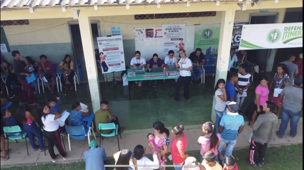 oto colorida na horizontal mostrando os serviços a Coordenadoria de Violência Doméstica do Tribunal de Justiça de Roraima em um polo na comunidade com várias habitantes locais esperando serem atendidos.