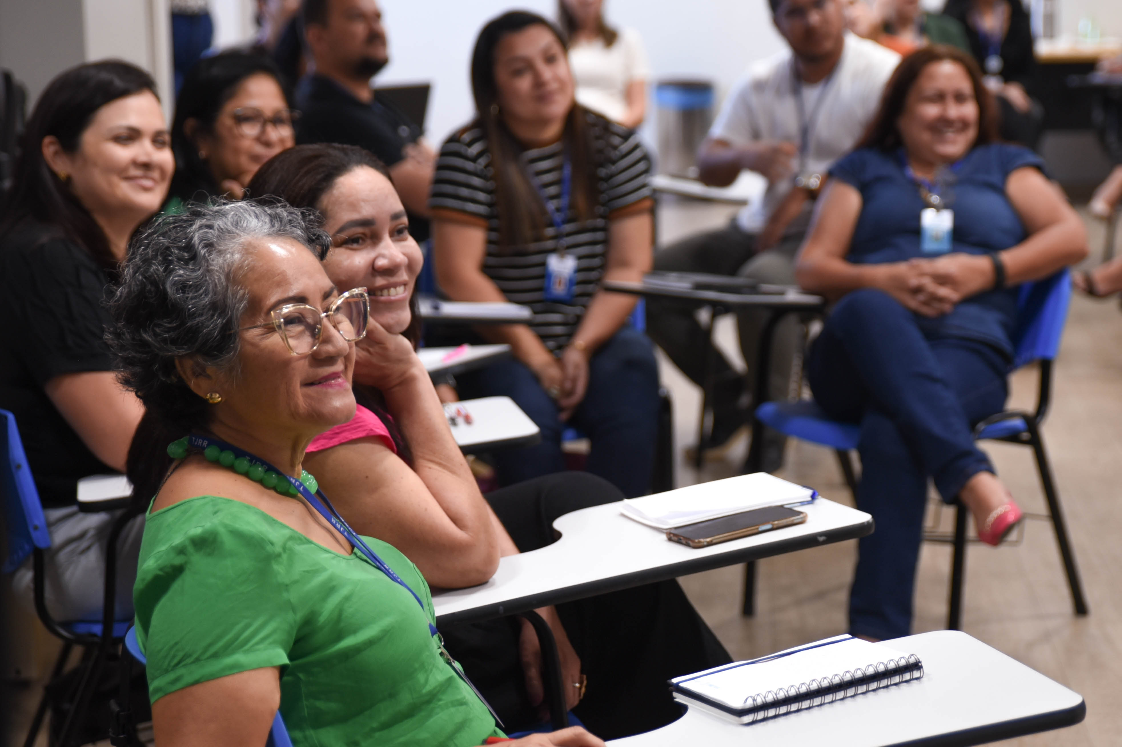 foto colorida em sala com vários servidores do TJRR sentados em cadeiras de estudantes