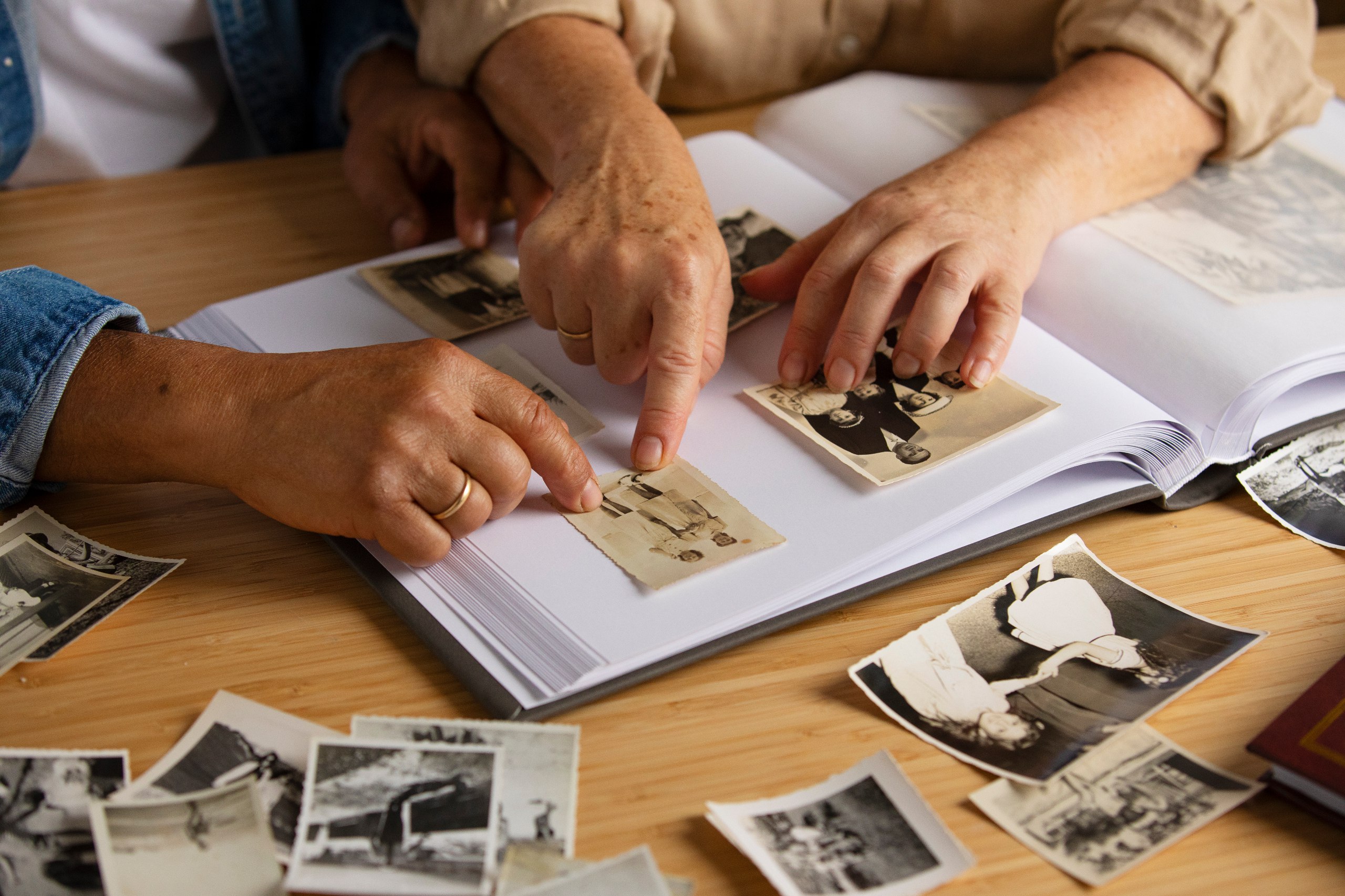 ilustração dando enfoque em duas mãos de um casal manuseando fotografias em um livro