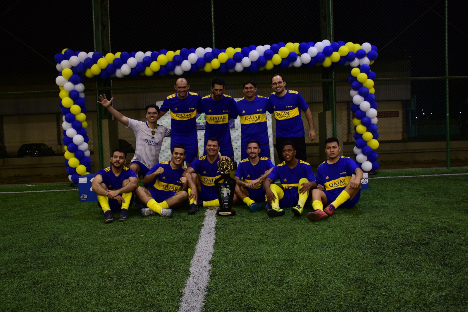  Imagem colorida mostra os três times, primeiro, segundo e terceiro lugar posando para fotografia durante premiação após final de campeonato