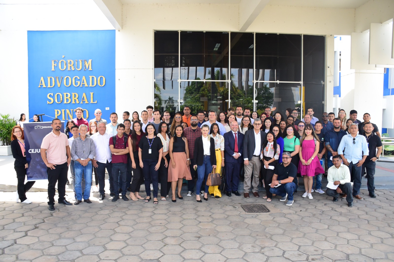 FOTO COLORIDA DE TODA A TUMA POUSANDO PARA A FOTOGRAFIA NA FRENTE DO FORUM