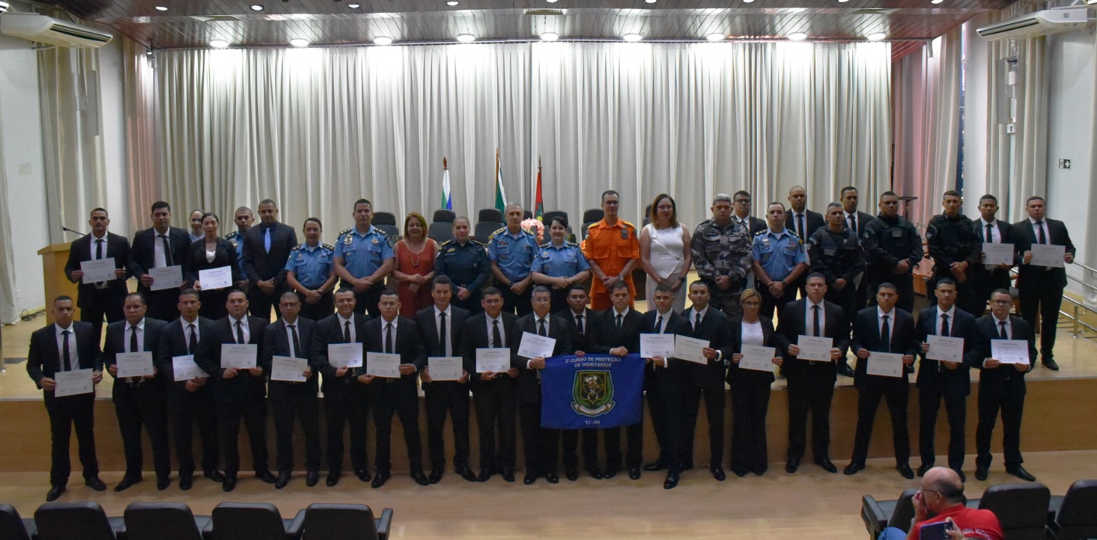 foto colorida de toda turma pousando para a fotografia e segurando os certificados