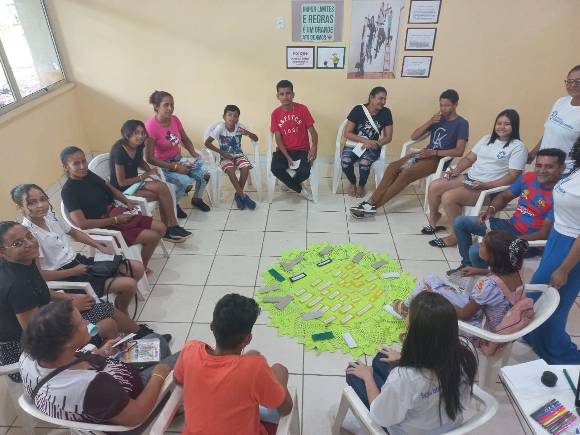 Foto colorida mostrando pessoas reunidas em um círculo, durante uma das rodas de conversas realizadas pelo Programa.