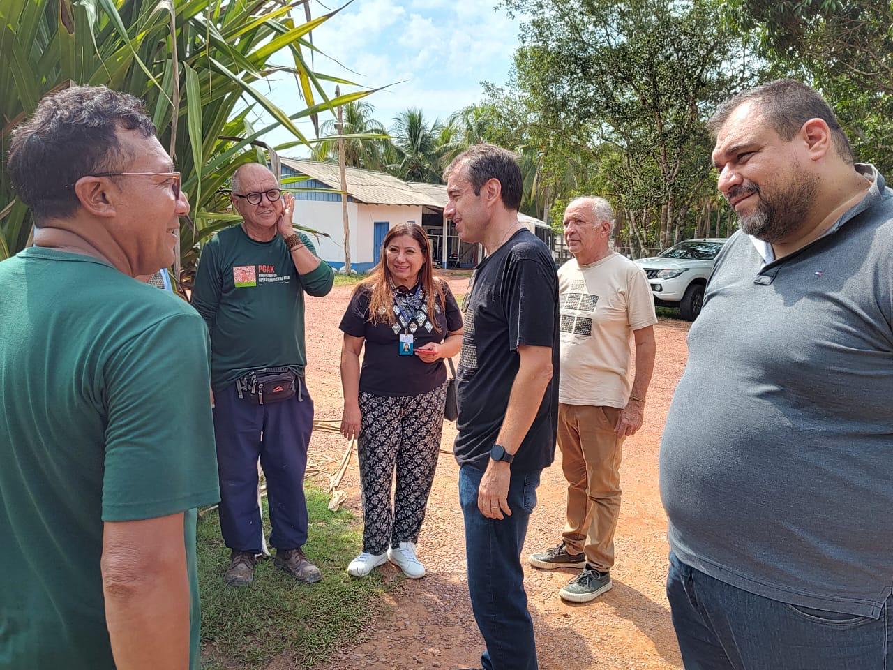 Foto colorida de servidores da Ouvidoria do TJRR reunidos em meio a àrvores.