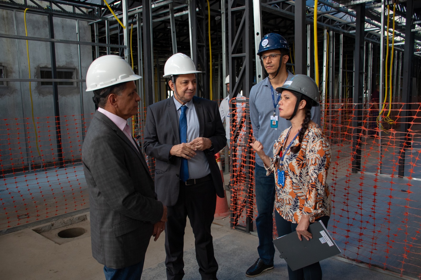 foto colorida do presidente do Tribunal de Justiça de Roraima (TJRR), desembargador Jésus Nascimento, acompanhado pelo senador Messias de Jesus, do secretário–geral do TJRR, Henrique Tavares, e mais uma servidores do Poder Judiciário com capacete de obras dentro do fórum em reforma