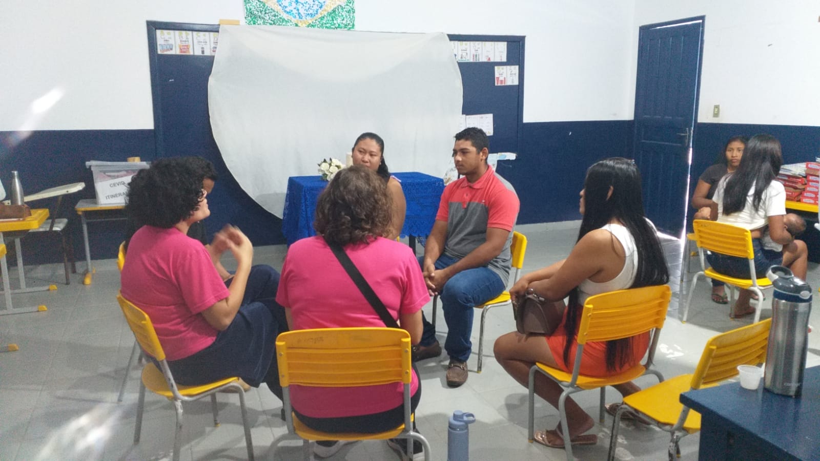 foto colorida cinco pessoas em um círculo de roda de conversa em uma escola 