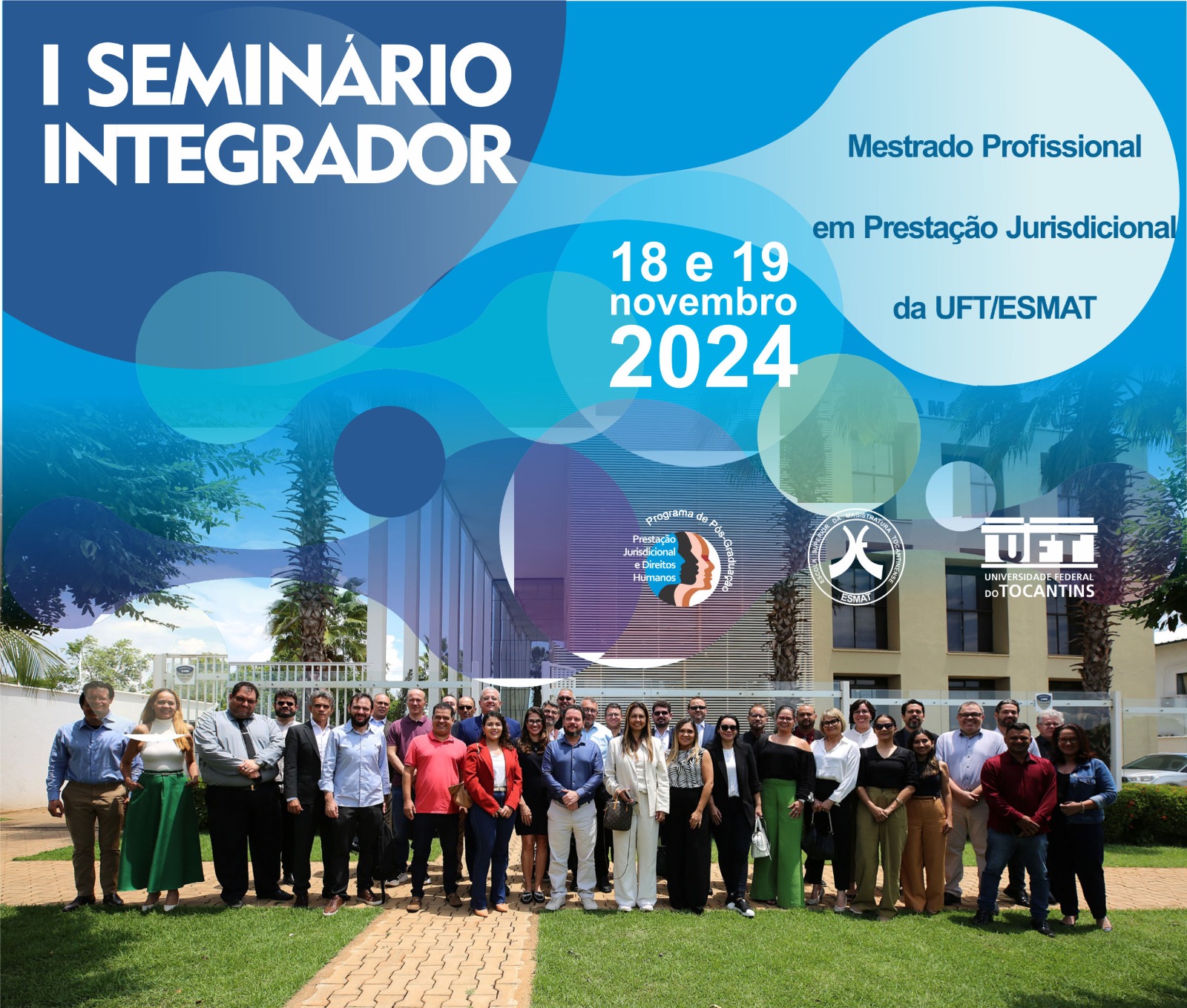 Foto colorida mostra aproximadamente 40 pessoas em pé posando para a foto em um card azul sobre o "I Seminário Integrador"