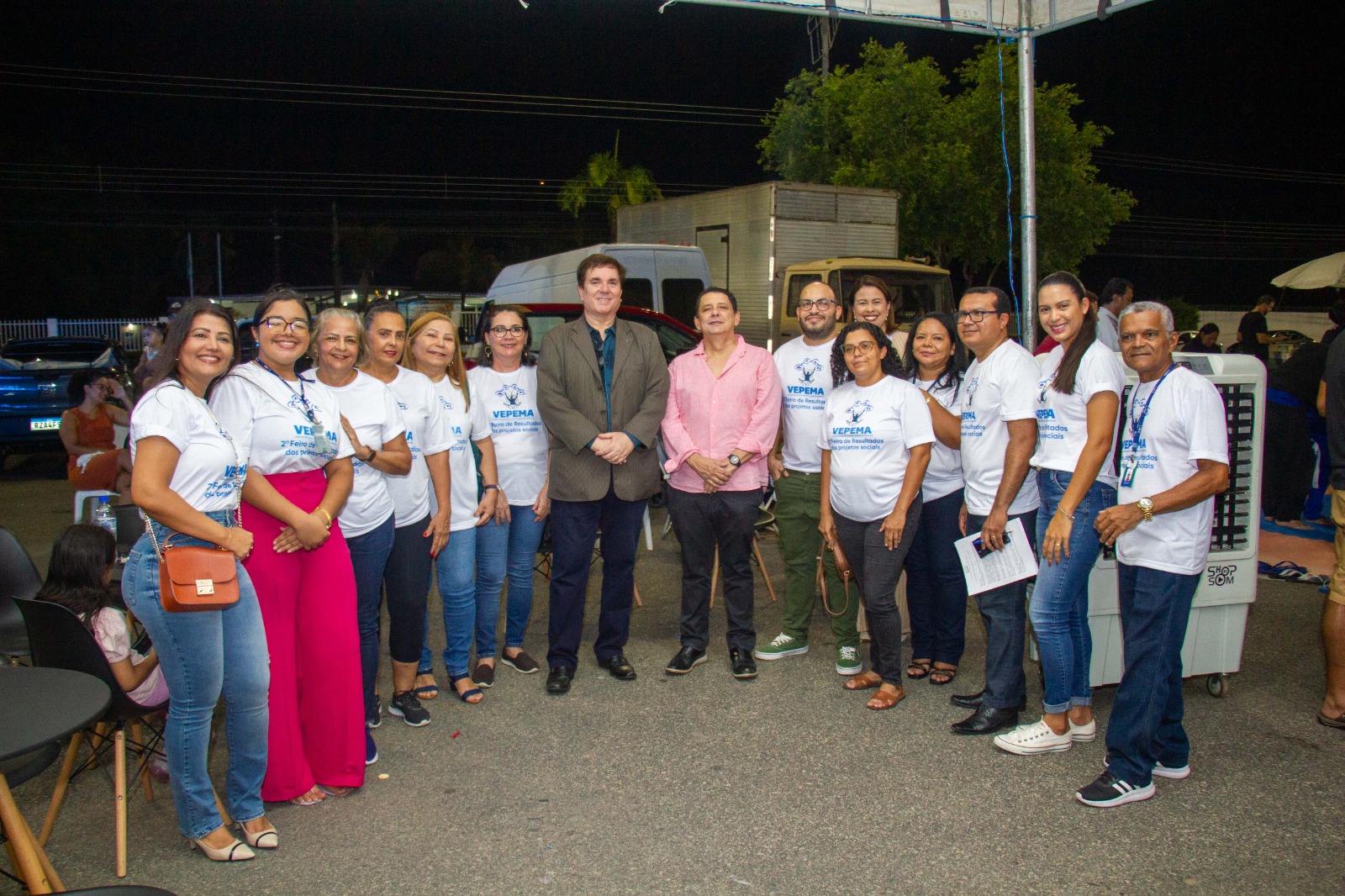 Foto colorida mostrando o presidente do Tribunal de Justiça de Roraima, desembargador Jésus Nascimento, juntamente com o juiz titular da Vepema, Alexandre Magno, posando para foto com participantes dos projetos sociais parceiros da Vepema. Abaixo o título: “FEIRA DE RESULTADOS - Histórias de superação e transformação social são possíveis com o apoio da Vepema”