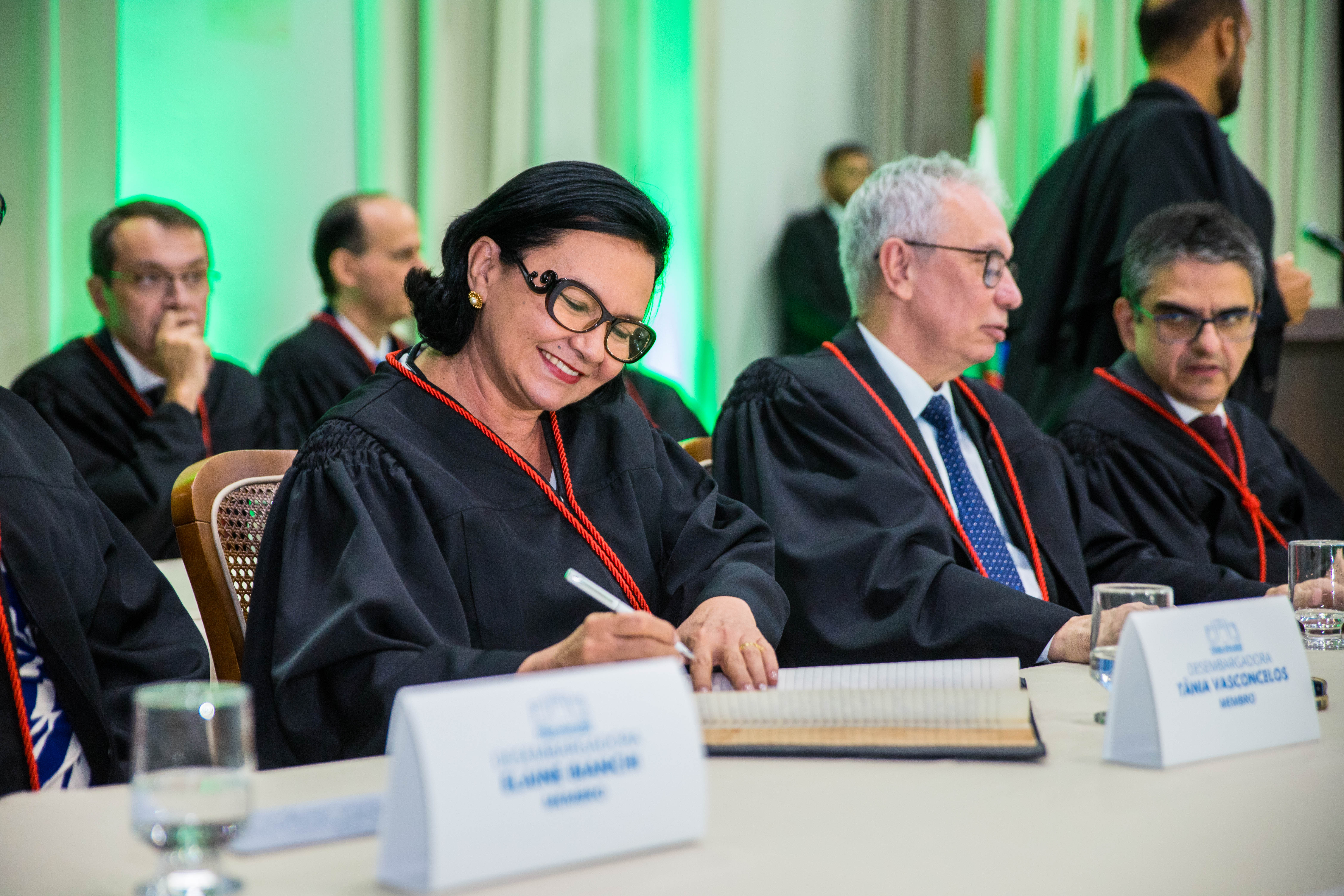 Foto colorida mostrando a desembargadora Tânia Vasconcellos assinando termo de posse