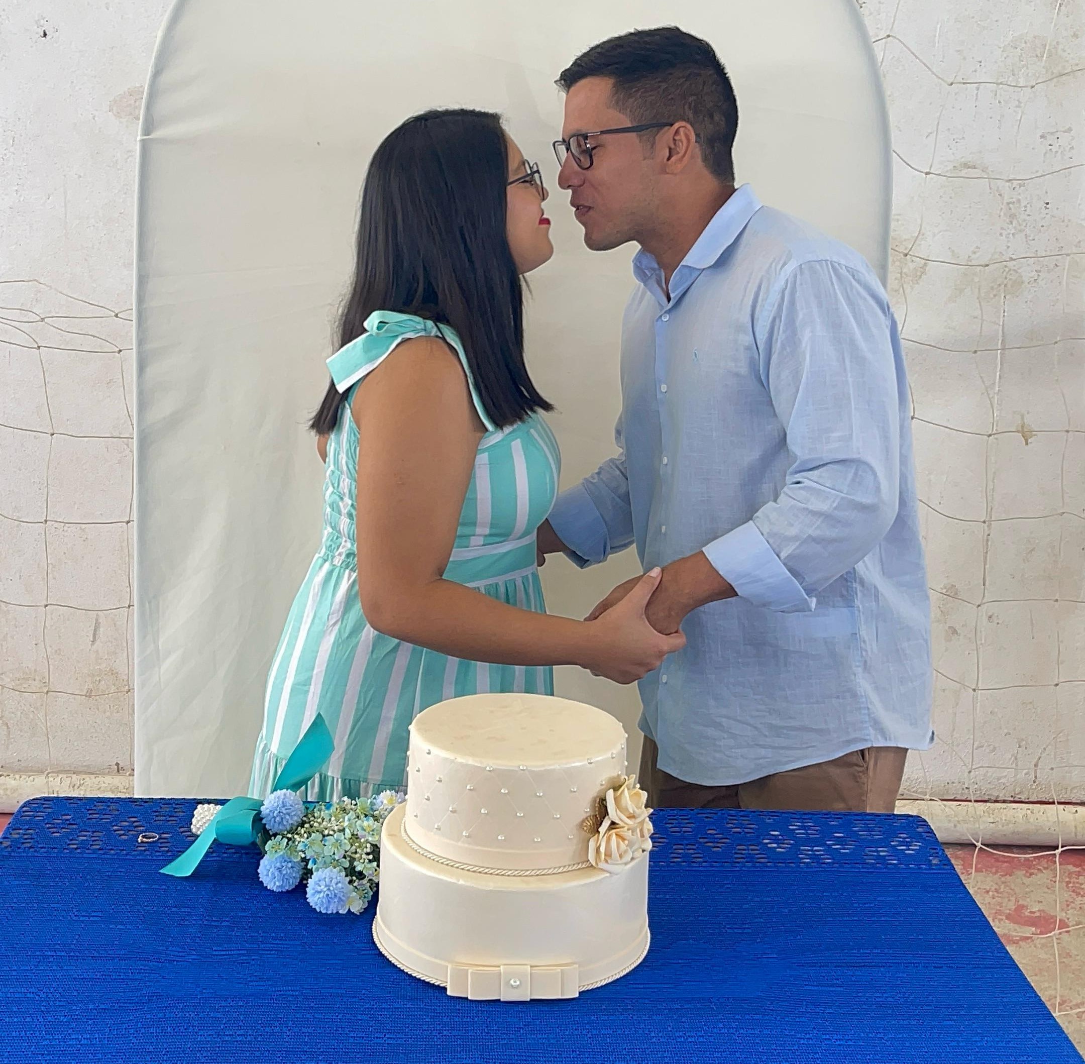 Imagem colorida contém o casal Leandro Leal e Pamela Patricia, se beijando sobre o bolo de casamento, durante ação da Vara da Justiça Itinerante no município de Iracema. Imagem colorida contém o casal Leandro Leal e Pamela Patricia, se beijando sobre o bolo de casamento, durante ação da Vara da Justiça Itinerante no município de Iracema.