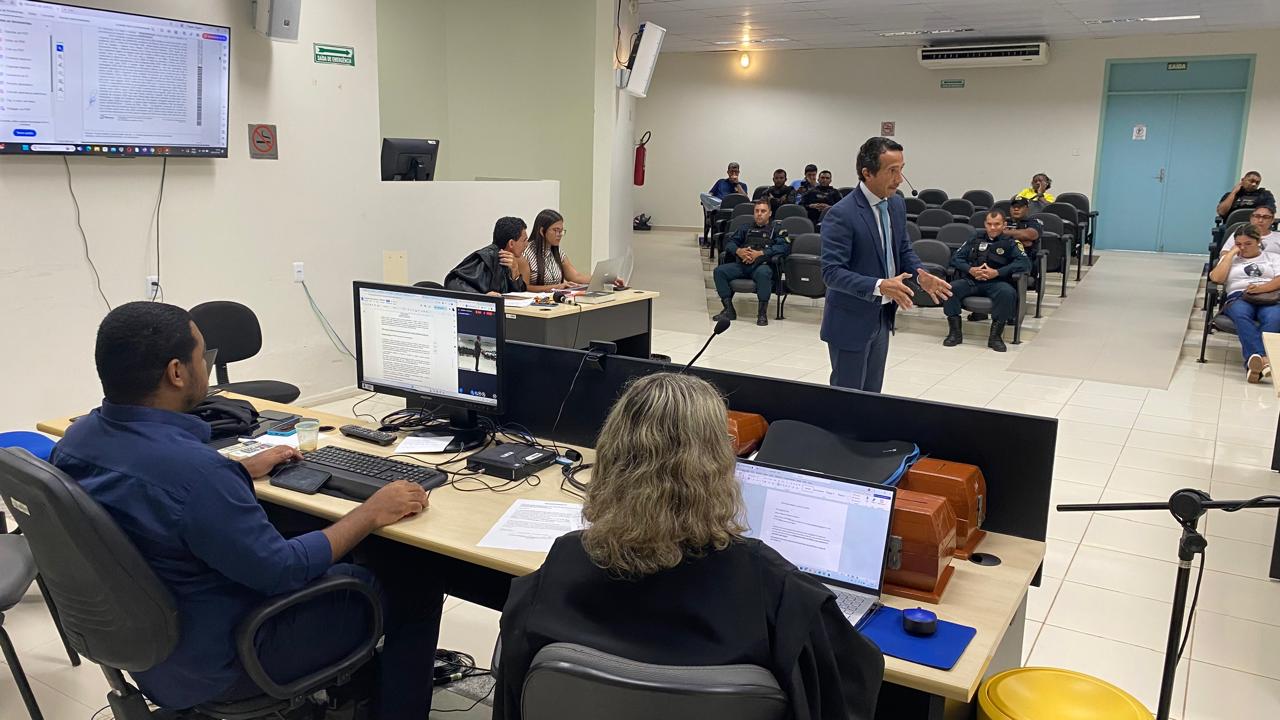 Foto colorida da Juri na Comarca de Alto Alegre. A foto mostra um homem, em frente ao Juri argumentando. Atras dele cadeiras de um auditório Foto colorida da Juri na Comarca de Alto Alegre. A foto mostra um homem, em frente ao Juri argumentando. Atras dele cadeiras de um auditório