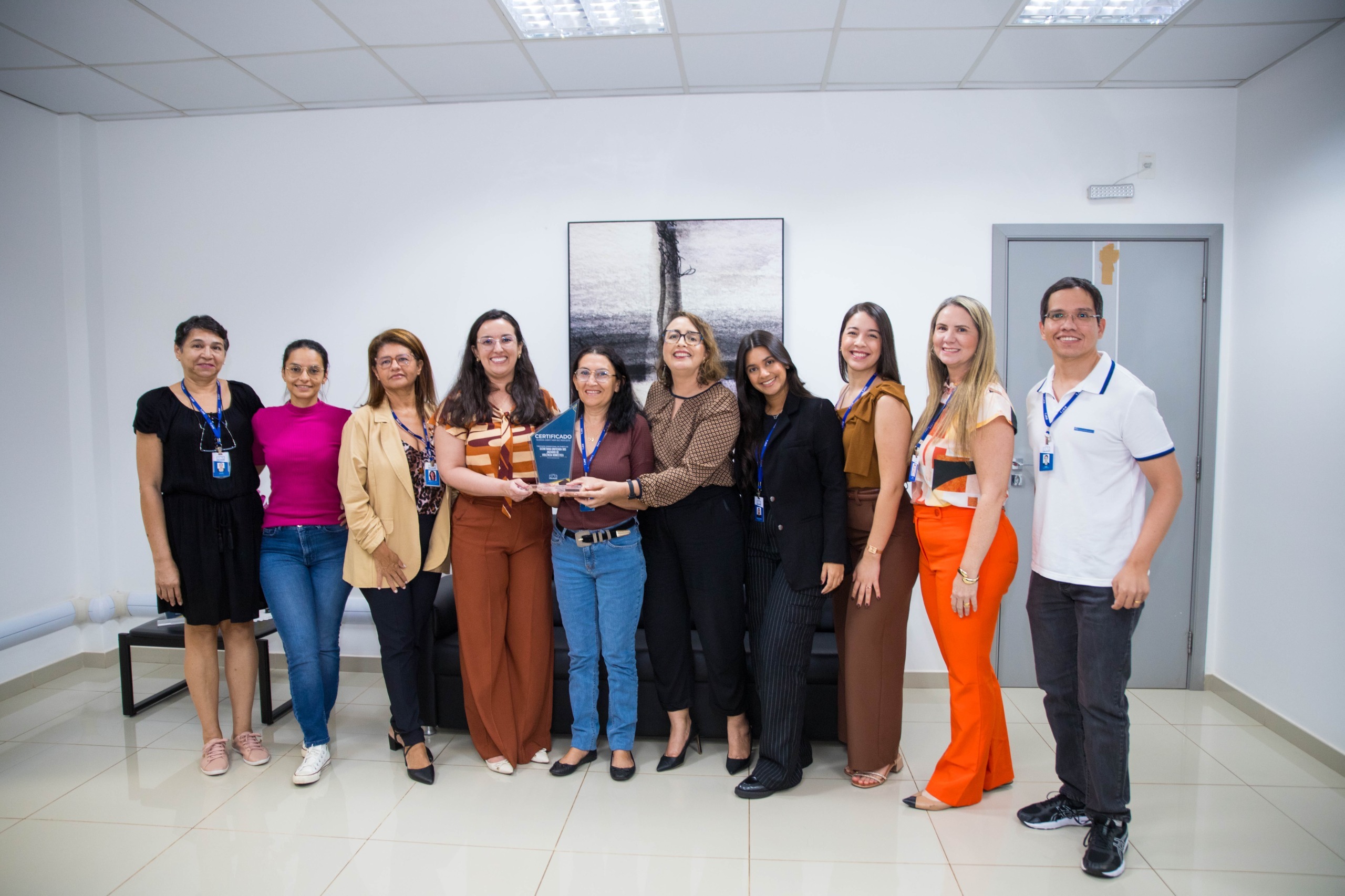 Imagem colorida contém a juíza titular do 3º Juizado Especial Cível, Bruna Guimarães Bezerra Fialho,segurando placa de premiação da certificação do ISO 9001, e posando para fotografia ao lado da Juíza Auxiliar da Presidência do TJRR, Lana Leitão, da Subsecretária de Processos e Gestão da Qualidade, Erika Horta e mais 12 servidores do TJRR. Imagem colorida contém a juíza titular do 3º Juizado Especial Cível, Bruna Guimarães Bezerra Fialho,segurando placa de premiação da certificação do ISO 9001, e posando para fotografia ao lado da Juíza Auxiliar da Presidência do TJRR, Lana Leitão, da Subsecretária de Processos e Gestão da Qualidade, Erika Horta e mais 12 servidores do TJRR.