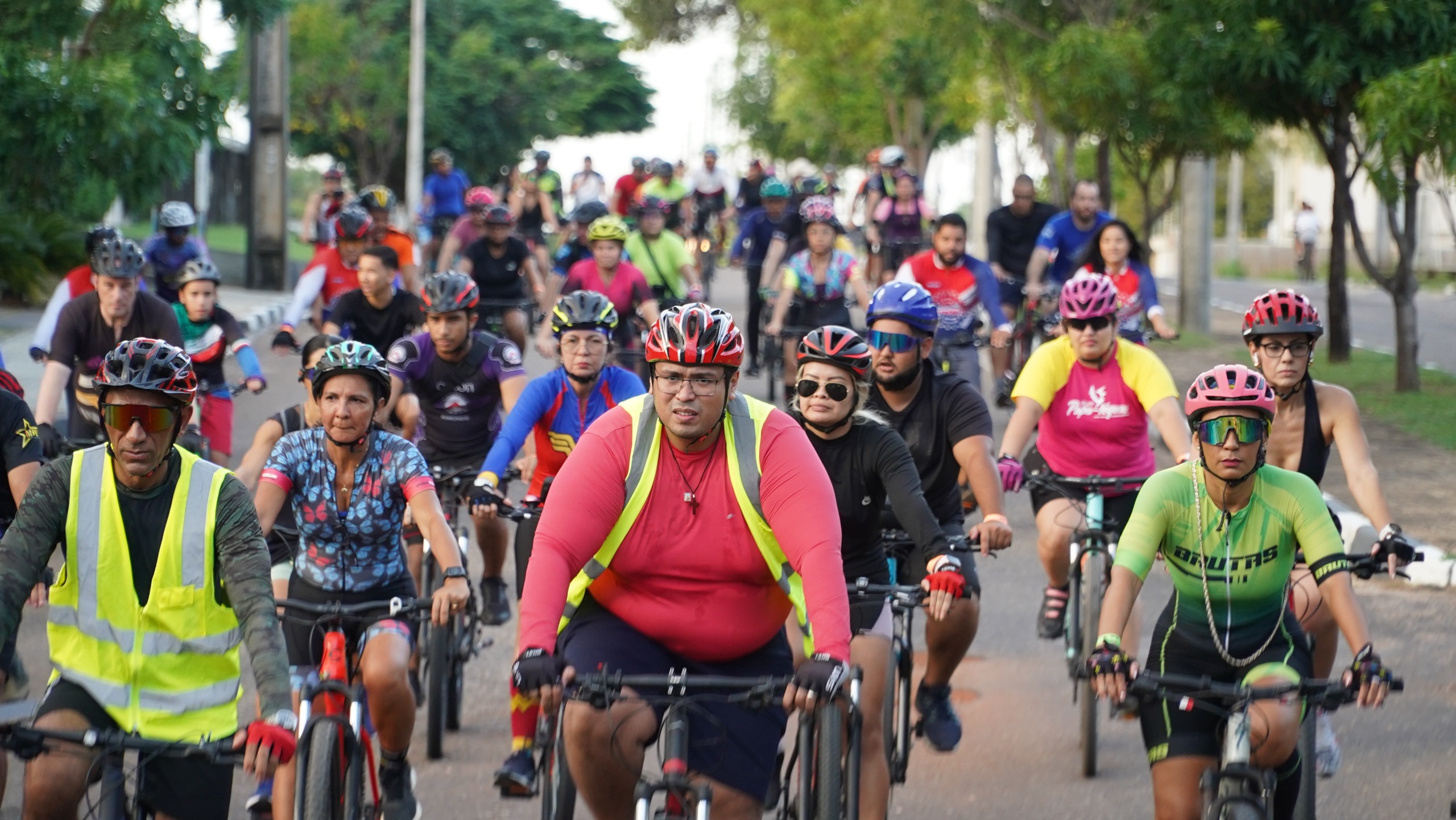 Imagem colorida mostra dezenas de ciclistas pedalando durante o IV passeio ciclístico do TJRR, realizado no dia 26 de abril de 2025.