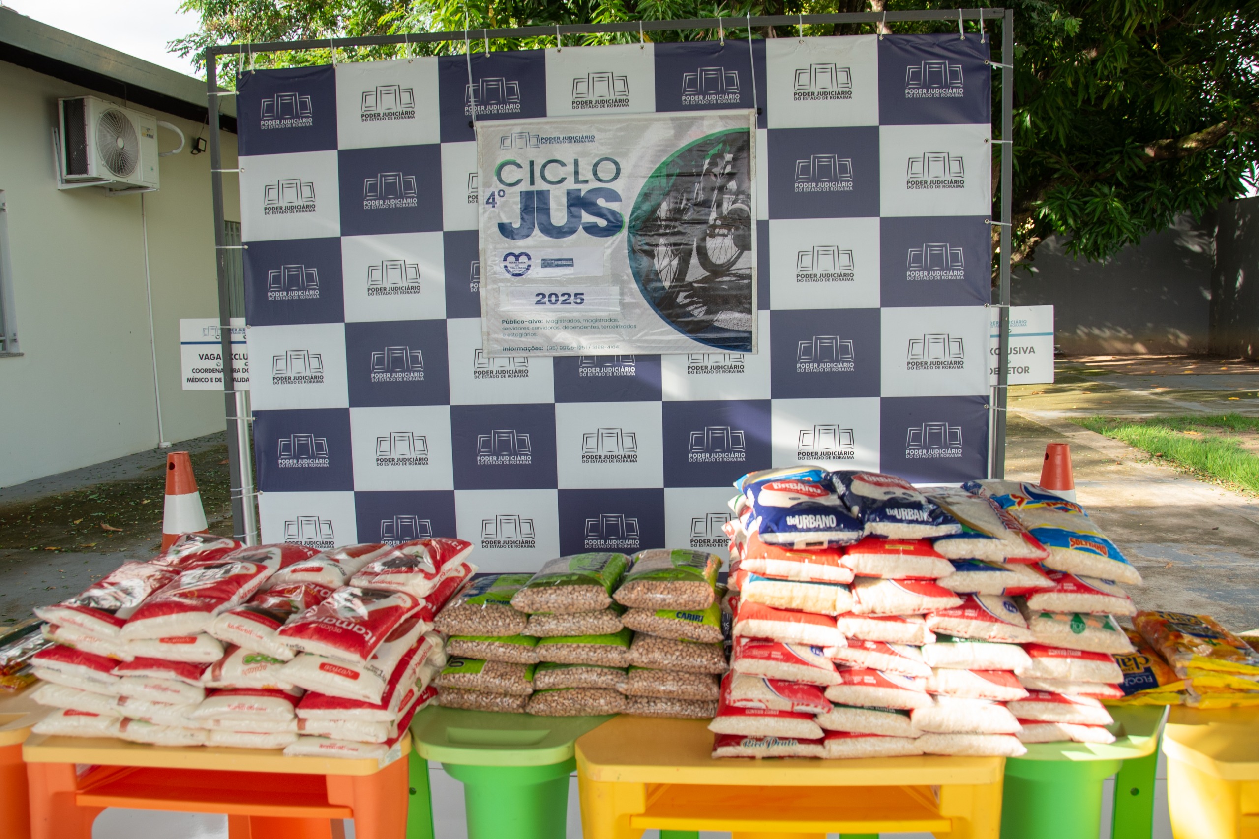 Imagem colorida mostra aproximadamente 150 quilos de alimentos não perecíveis arrecadados durante a inscrição do passeio ciclístico do TJRR.