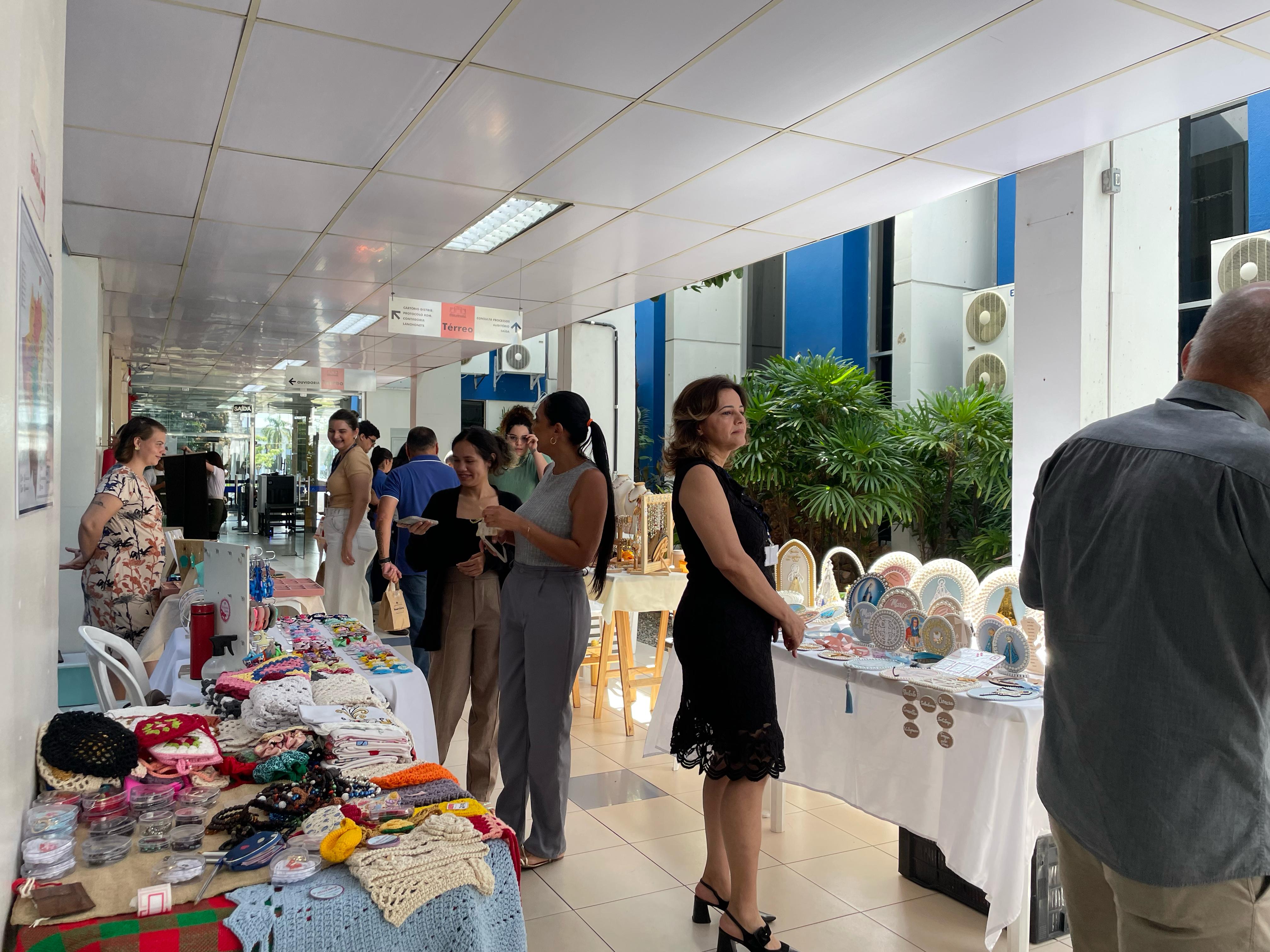imagem colorida em plano aberto no hall do Fórum Cível mostrando as pessoas na feira de artesanato