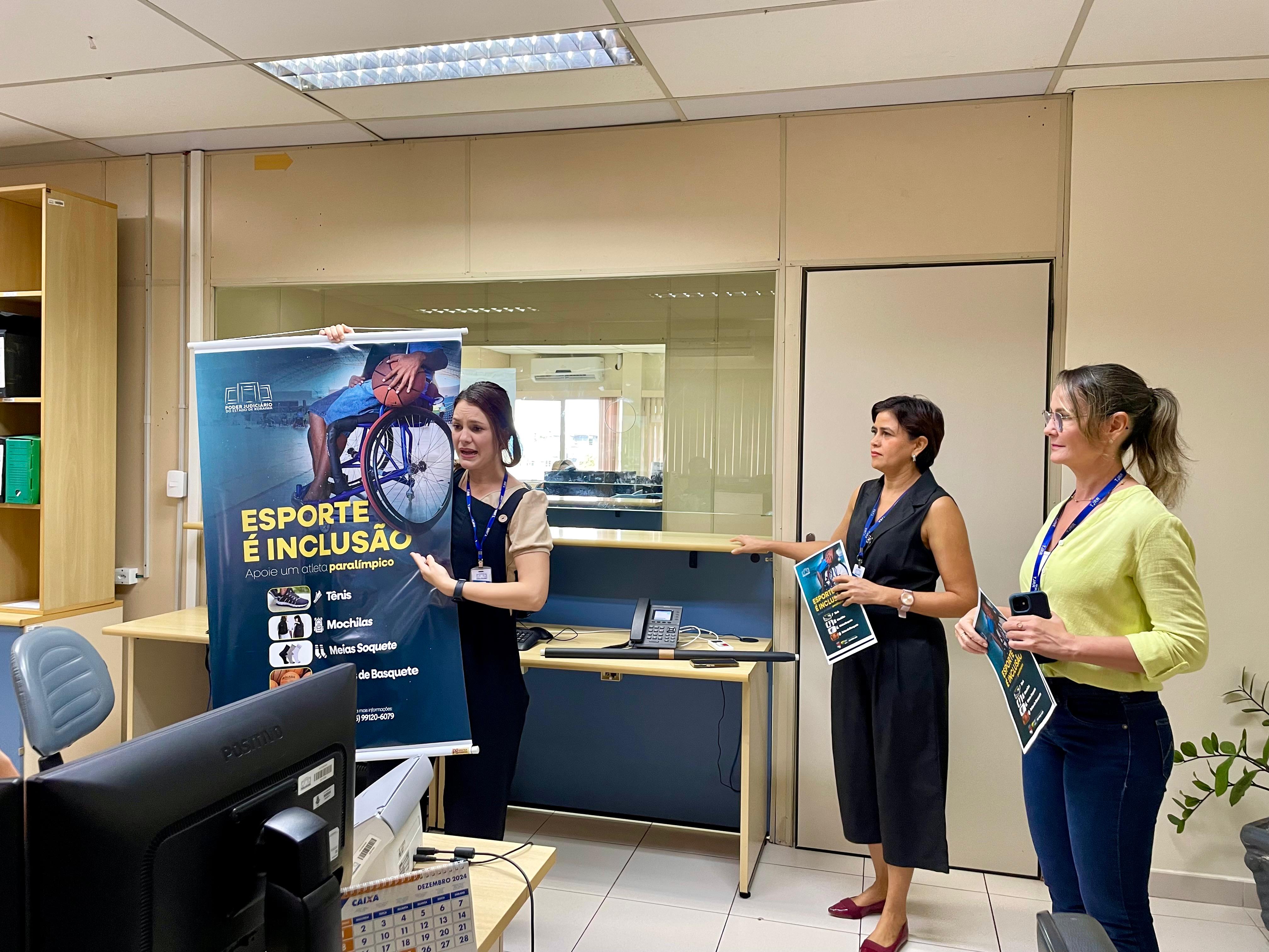 Foto colorida de três pessoas da comissão falando sobre a campanha. Uma delas está segurando um banner.