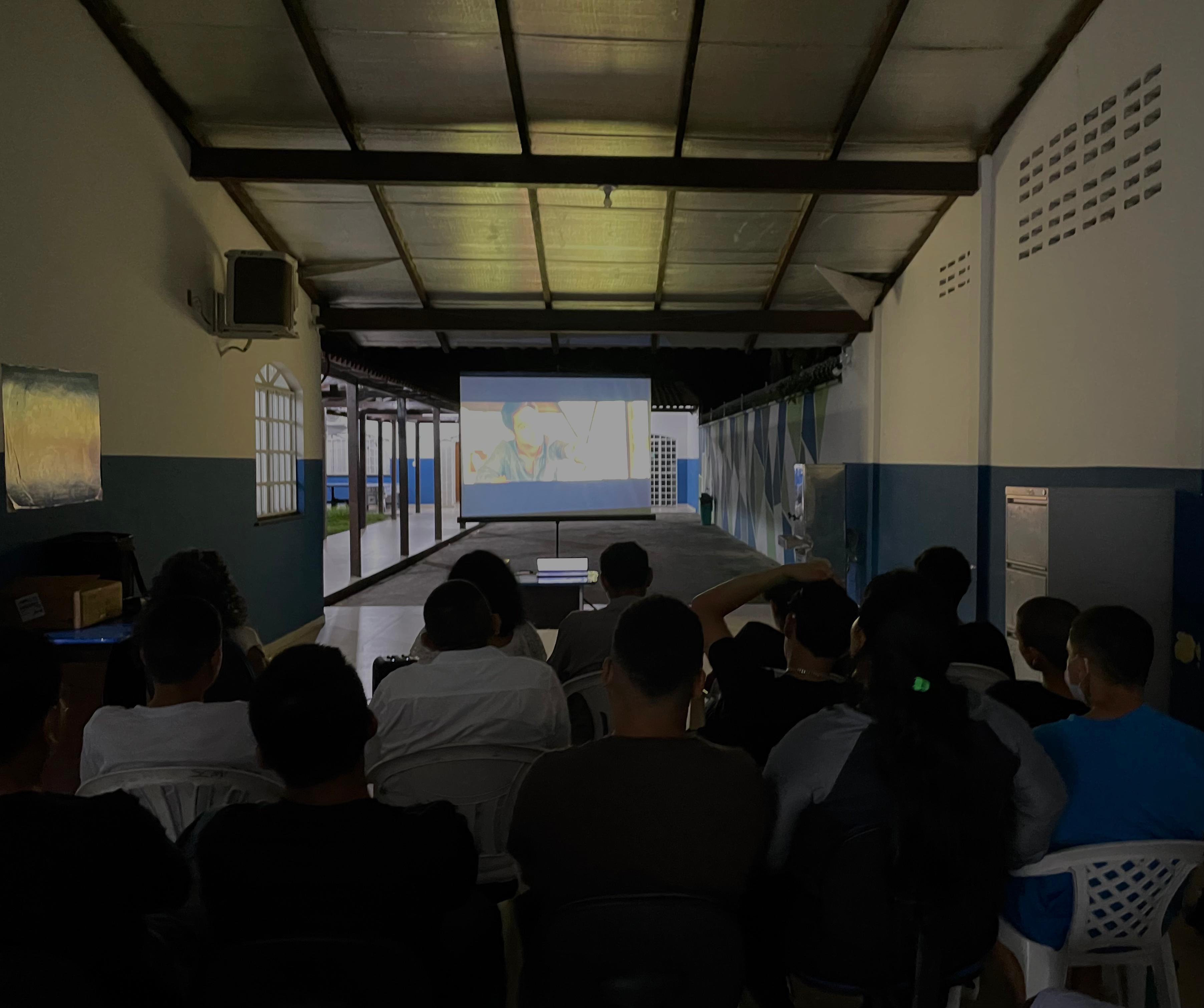 foto colorida dos jovens assistindo filme em um ambiente meio fechado e escuro. foto colorida dos jovens assistindo filme em um ambiente meio fechado e escuro.