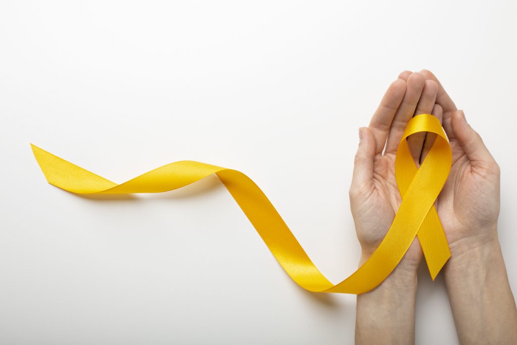 A imagem apresenta uma fita amarela sobre duas mãos, simbolizando a campanha setembro amarelo. O fundo é branco