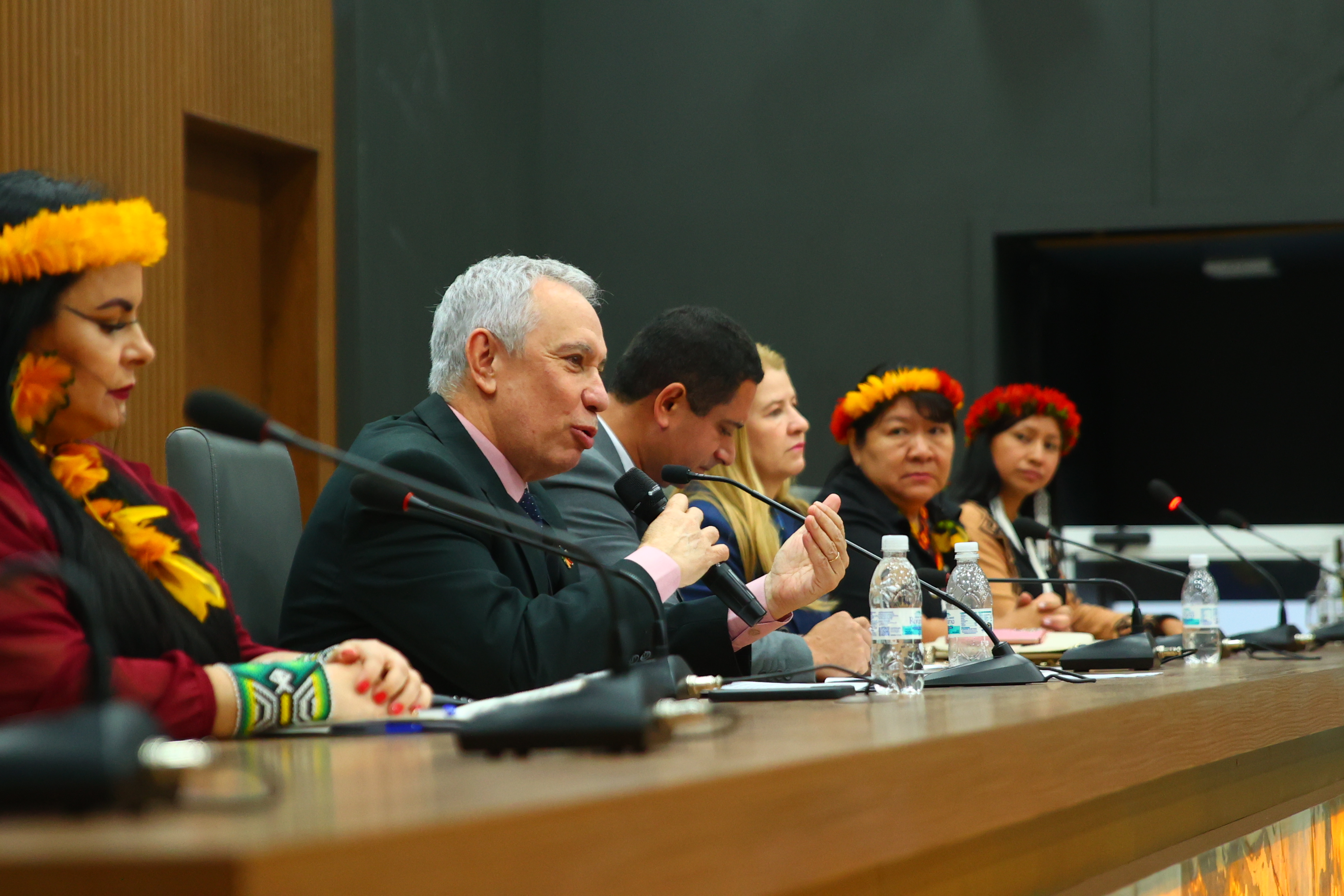 magem colorida do vice-presidente, Desembargador Almiro Padilha, na bancada de debate com demais autoridades, falando ao microfone durante o evento. magem colorida do vice-presidente, Desembargador Almiro Padilha, na bancada de debate com demais autoridades, falando ao microfone durante o evento.