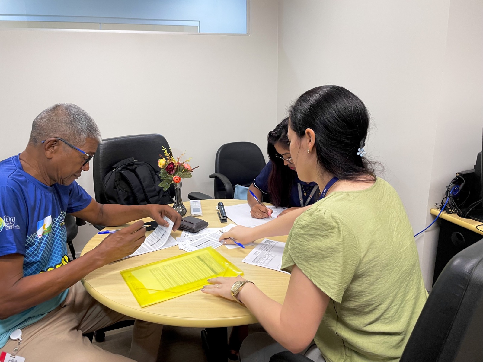 Imagem colorida durante um atendimento, Há duas mulheres na foto, uma da empresa de energia e outra do TJRR e um homem. Imagem colorida durante um atendimento, Há duas mulheres na foto, uma da empresa de energia e outra do TJRR e um homem.