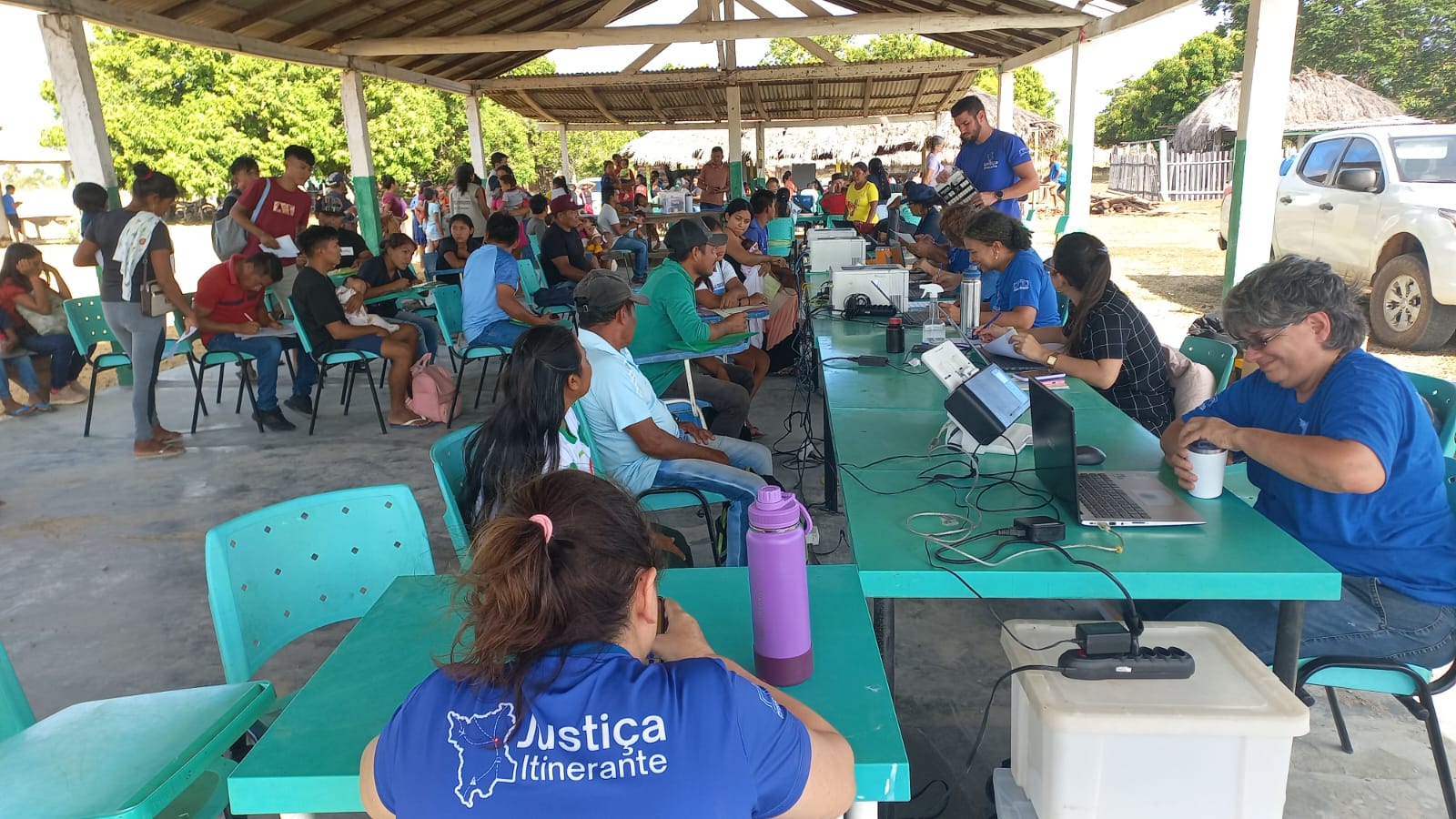 Grupo de pessoas sentadas em um espaço coberto durante atendimetno da Vara da Justiça Itinerante Grupo de pessoas sentadas em um espaço coberto durante atendimetno da Vara da Justiça Itinerante