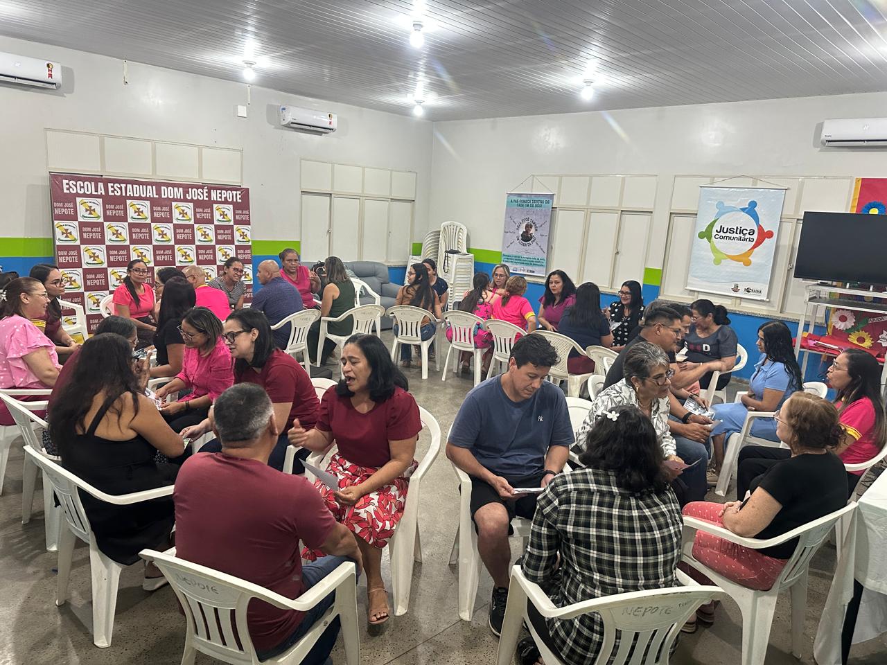 Imagem colorida de uma sala de aula com pessoas adultas sentadas em circulos