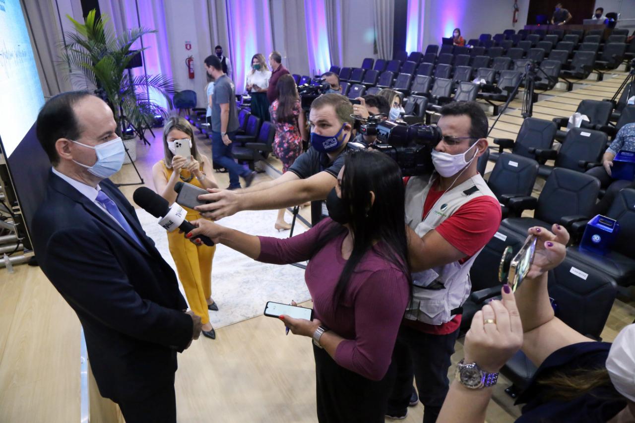 Foto do Presidente do Tribunal de Justiça, desembargador Cristóvão Suter, de pé em auditório, falando com a imprensa, repórter com microfone, cinegrafista e pessoas com celular na mão filmando e tirando fotos do Presidente.