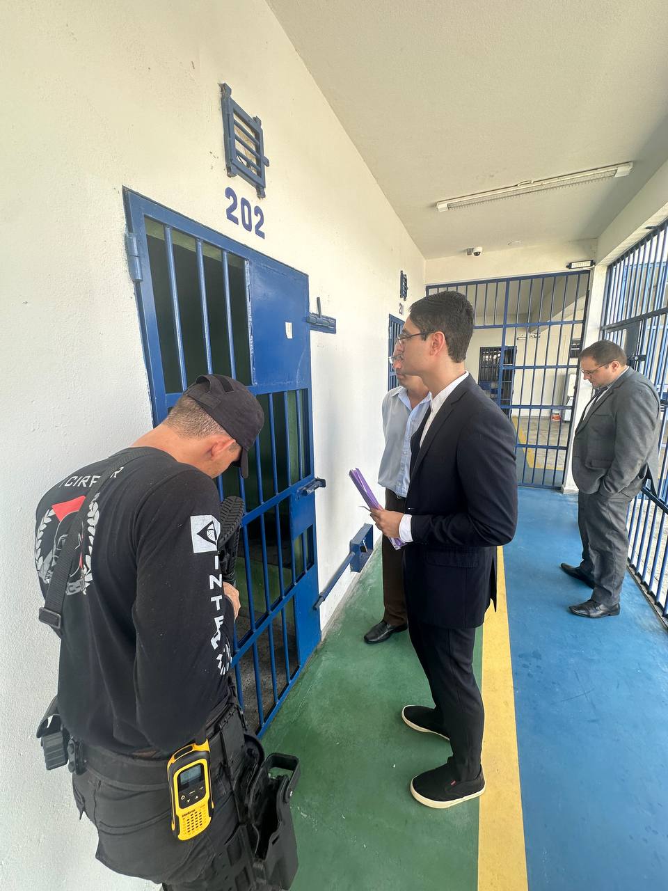 foto colorida na área interna do sistema prisional com os servidores do TJRR na frente de uma cela 