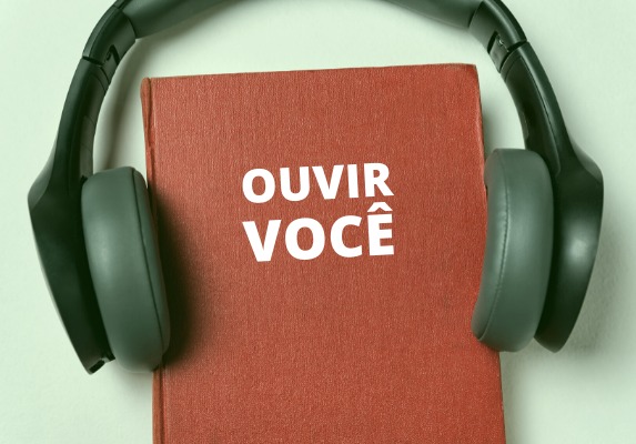 Livro vermelho escrito “ouvir você”, com fone de ouvido.