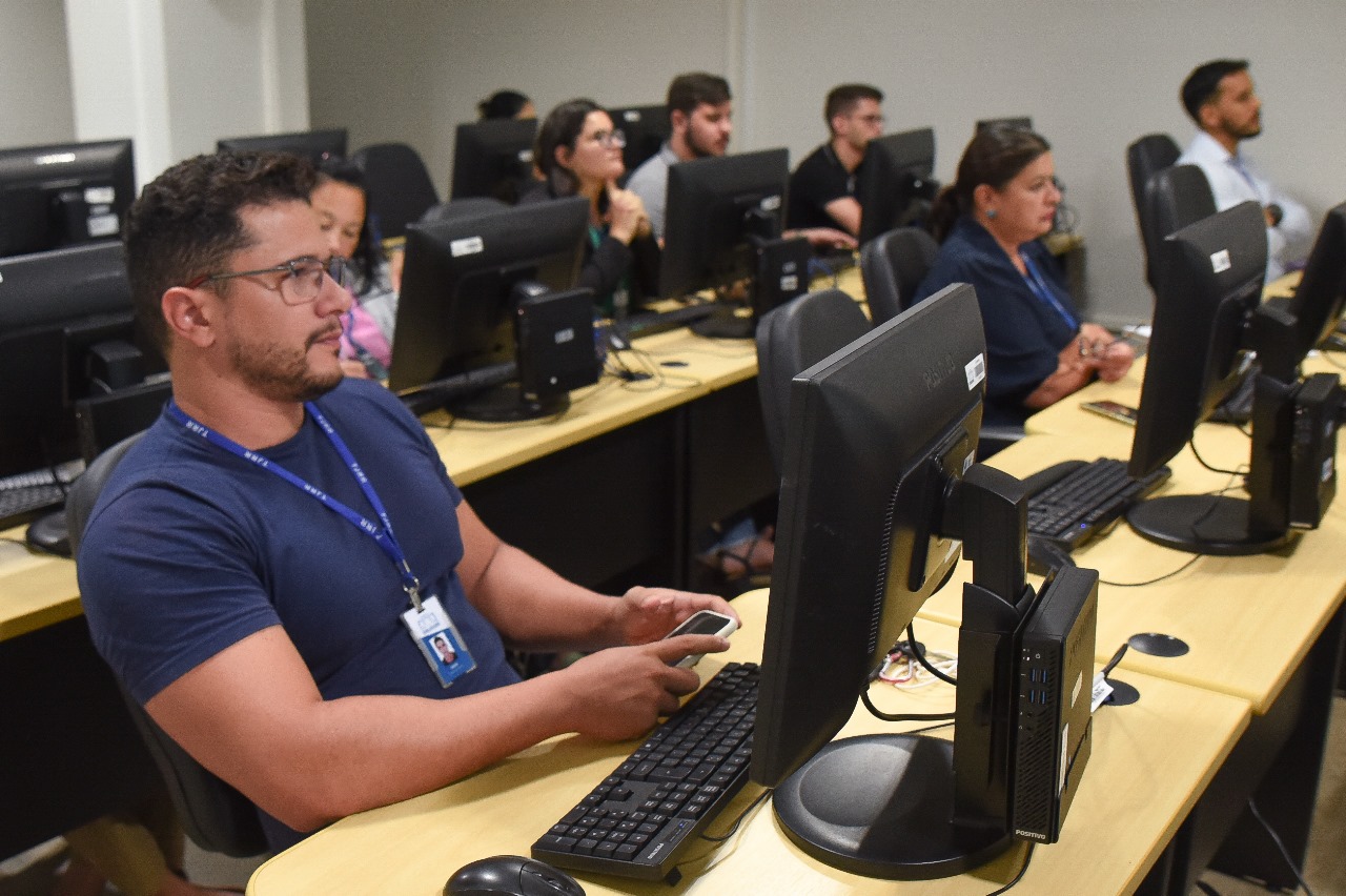 foto colorida de um servidor sentado em uma mesa com computador