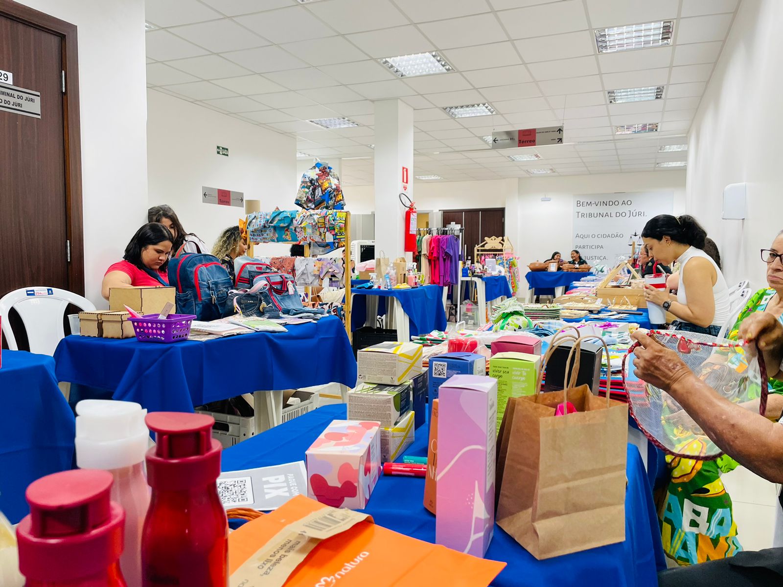 foto colorida expondo o hall com mesas cheias produtos da feira
