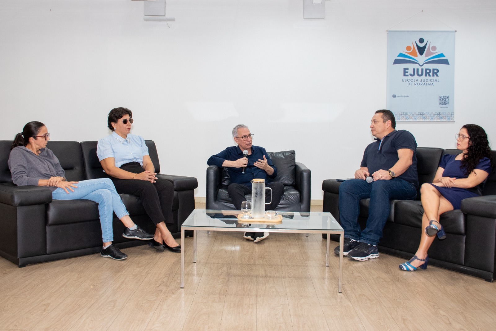 Foto colorida mostra cinco pessoas em roda de conversa sentados em sofá, ao centro o mediador da roda de conversa o desembargador Almiro Padilha. Ao redor, quatro integrantes da CPAI
