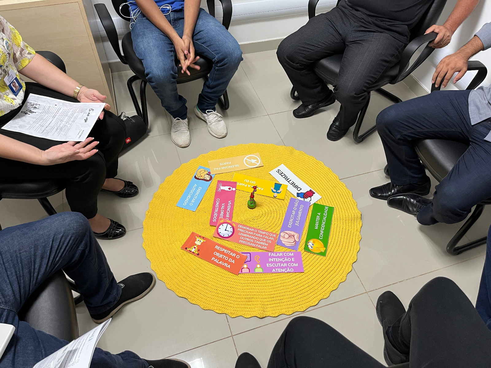 foto colorida de algumas pessoas sentadas nas carteiras em um círculo