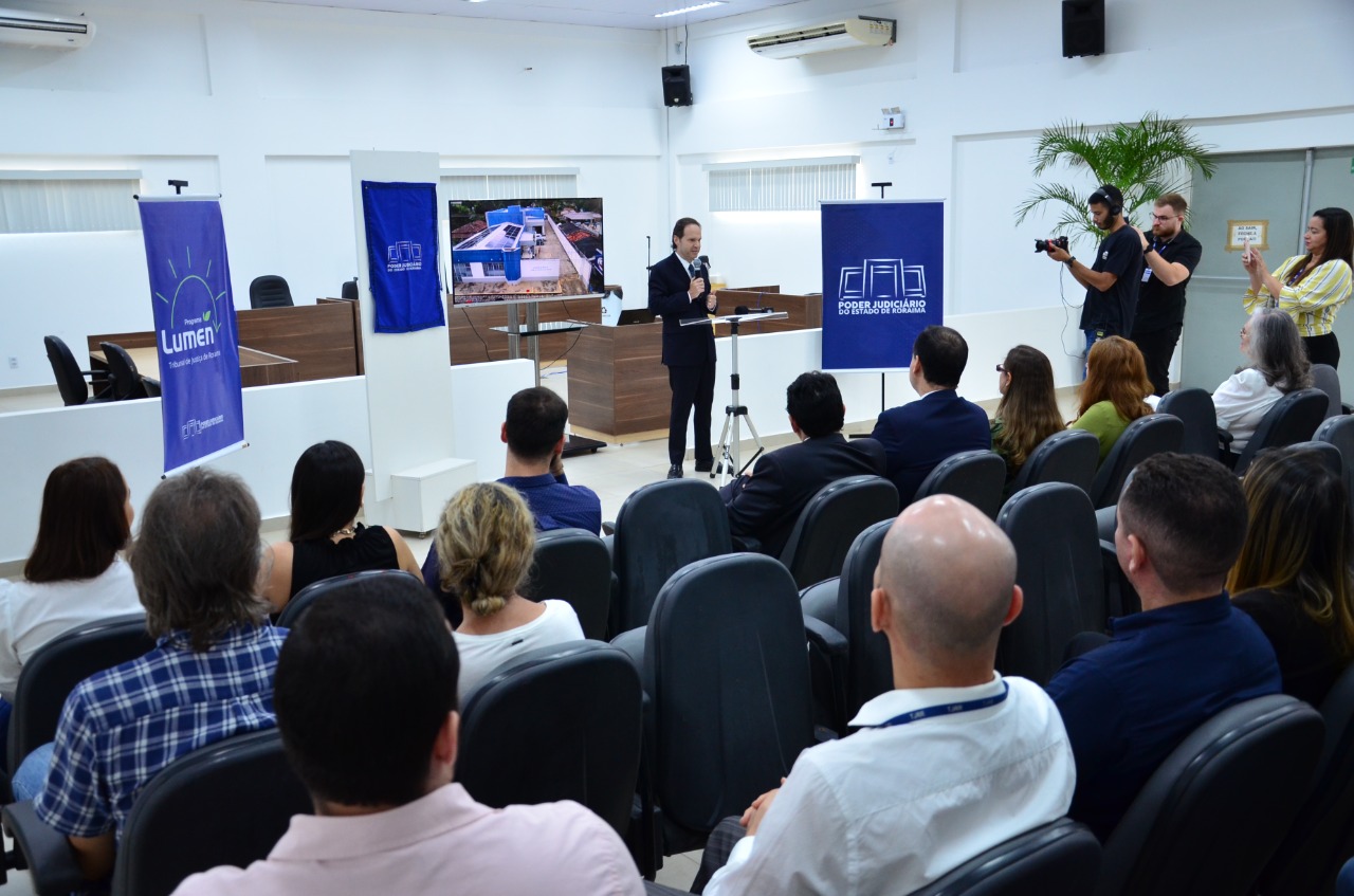 Imagem colorida contém o  ministro do STJ, Joel Ilan Pacionik, falando no microfone durante inauguração do sistema de geração de energia solar, na comarca de Mucajaí.