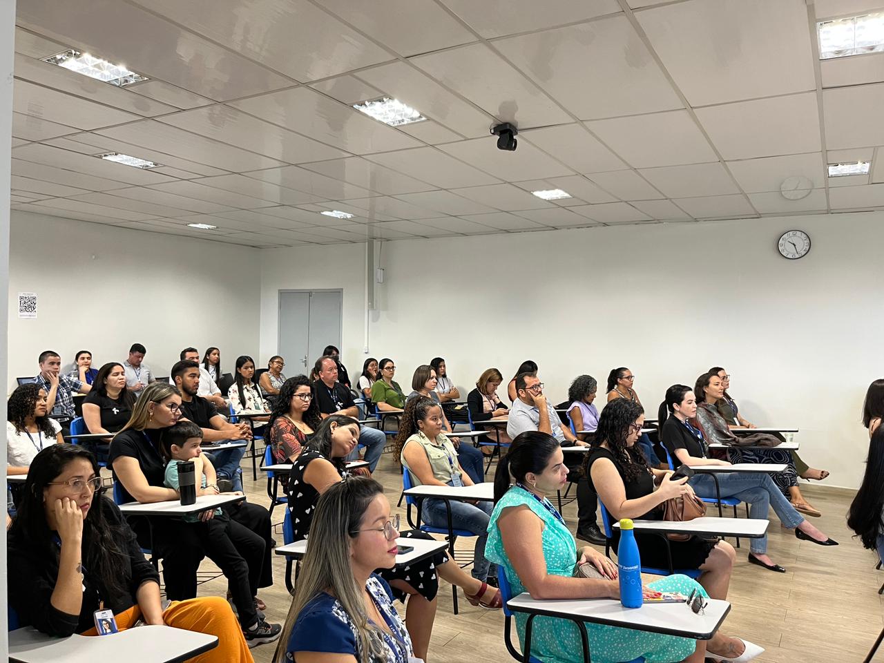 foto colorida de uma turma de servidores sentados em um auditorio