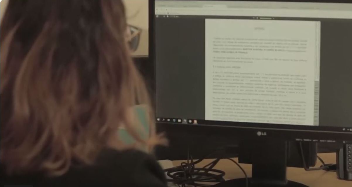 foto colorida mostra a mulher de frente a um computador.