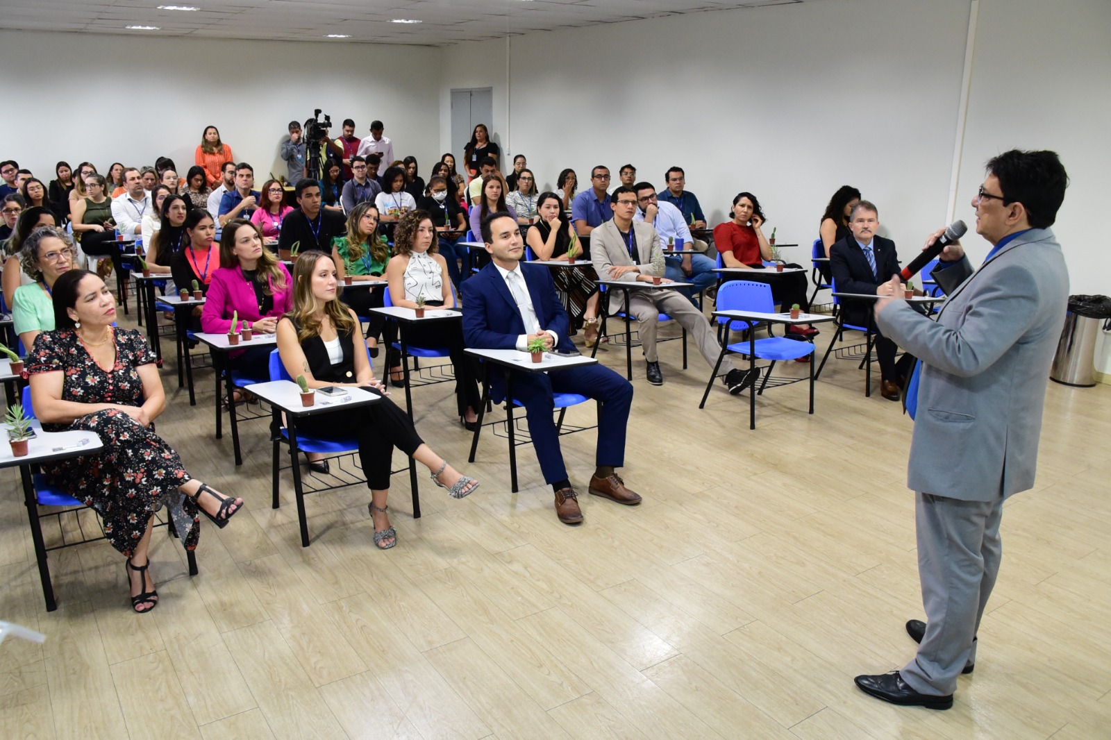 foto colorida mostra a direita o presidente do TJRR, desembargador Jésus Nascimento, em pé, falando ao microfone na solenidade de abertura da 7ª Semana do Meio Ambiente. Mais à esquerda estão cerca de 50 pessoas, sentadas em cadeiras azuis, acompanhando a fala do presidente