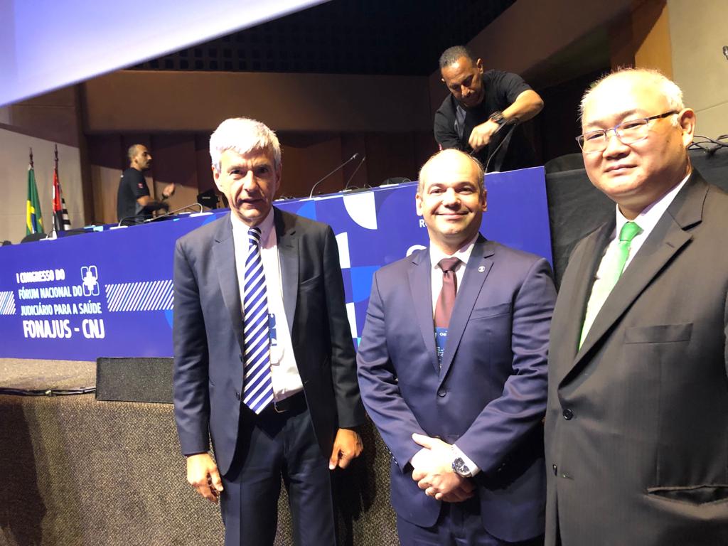 Imagem colorida em formato quadrado mostra o conselheiro do CNJ e supervisor do Fonajus, Richard Pae Kim, o juiz coordenador do Núcleo de Apoio Técnico do Judiciário Estadual (Natjus), Eduardo Álvares Carvalho e o presidente da Fundação Faculdade de Medicina, Arnaldo Hossepian, em pé, posando para a foto.