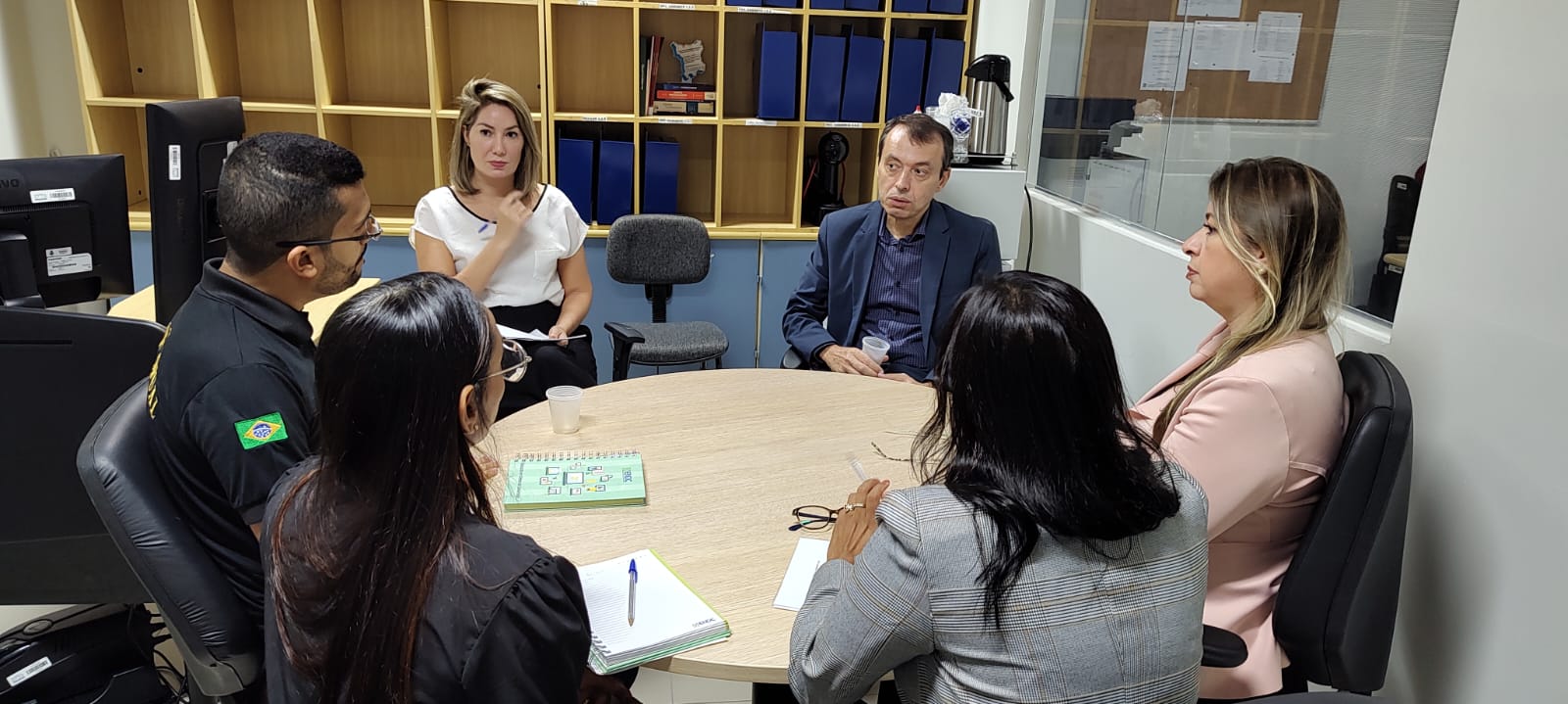 Imagem colorida mostra o ouvidor-geral do Tribunal de Justiça de Roraima (TJRR), desembargador Erick Linhares, e cinco pessoas, 1  homens e 4 mulheres sentado ao redor de uma mesa.