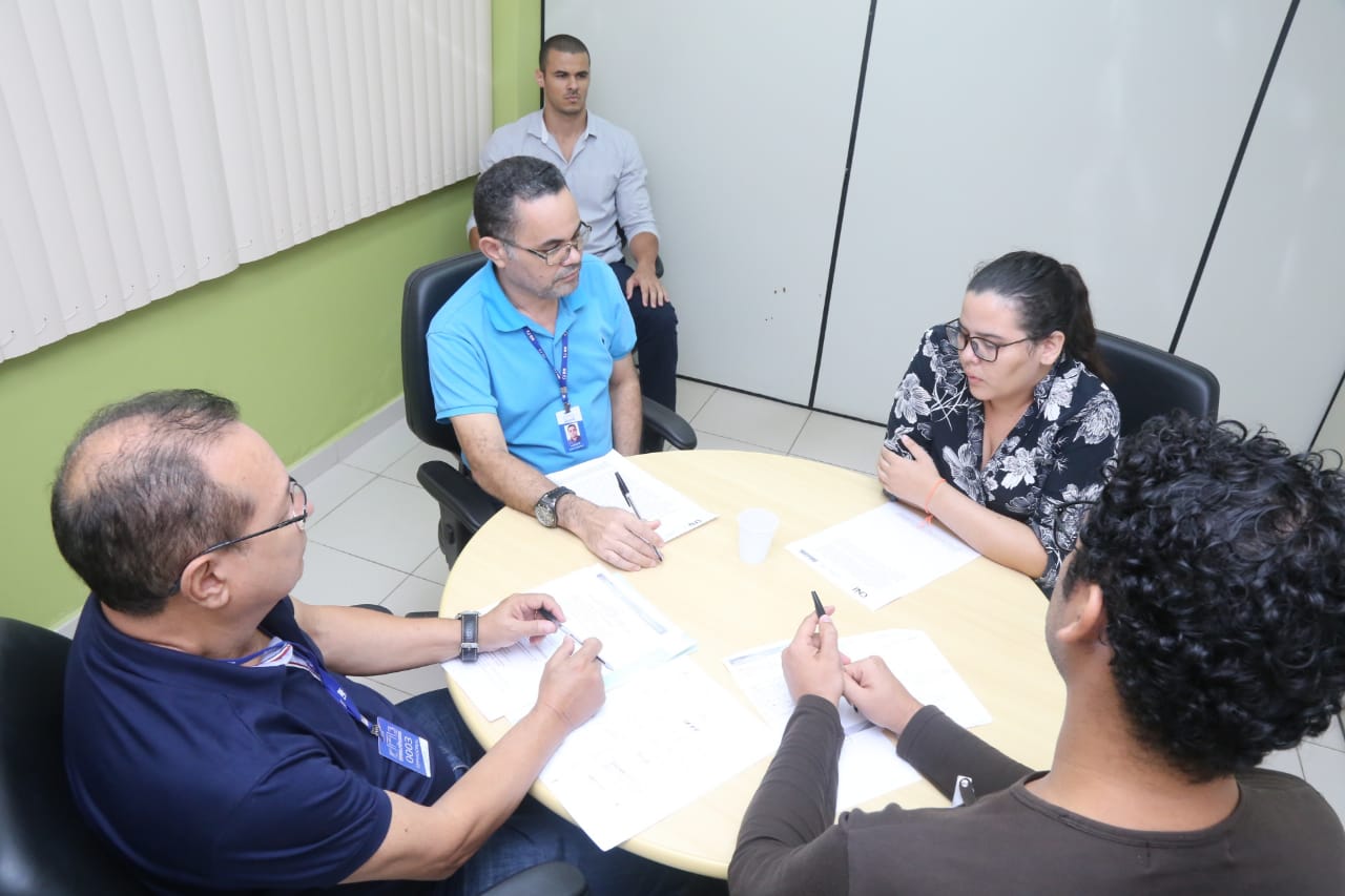 Pessoas em volta de uma mesa durante reunião de conciliação no Tribunal de Justiça 