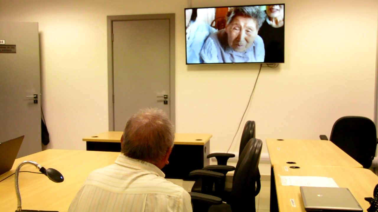 Videoconferência entre o Brasil e o Japão, momento em que os irmãos se reconhcem por meio da tramissao das imagens e som 