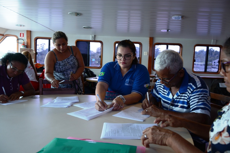 Ribeirinhos do Baixo Rio Branco e Negro, recebendo atendimento no barco pelas equipes da Justiça Itinerante e parceiros