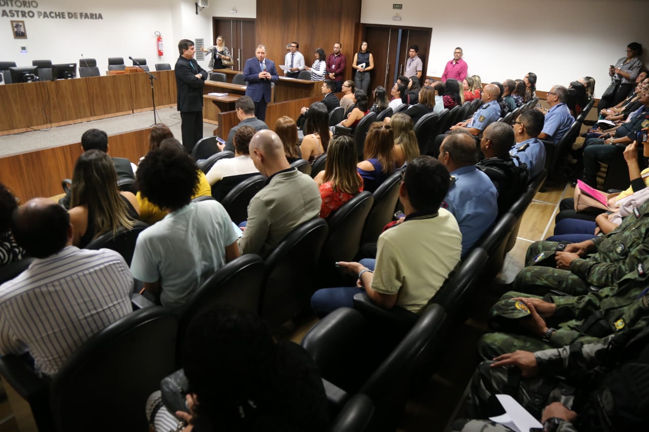 Momento da entrega dos alvarás, pessoas aguardam em um auditório dentro do Fórum Criminal. 