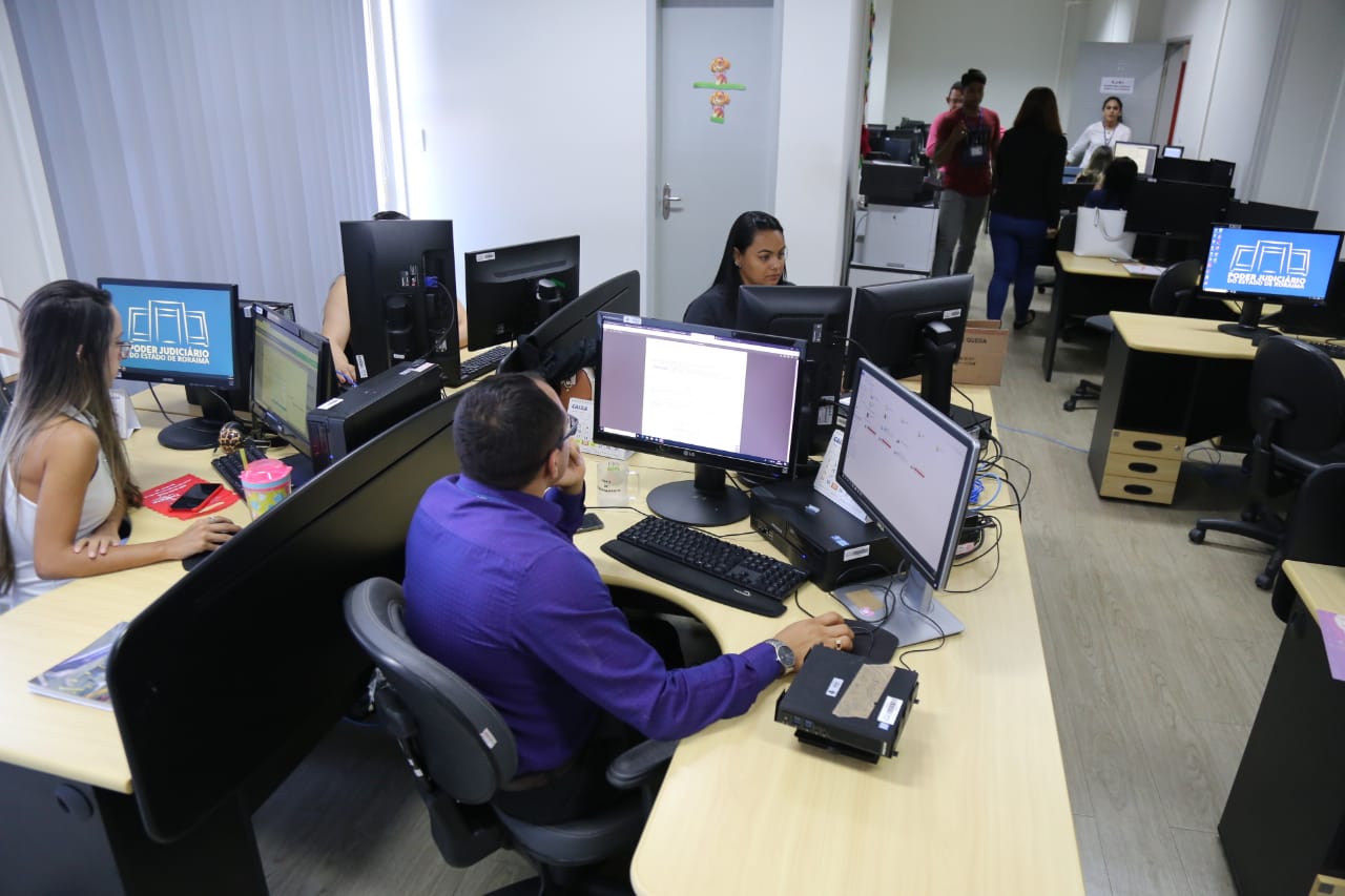 Servidores do Poder Judiciário de Roraima, em uma sala de trabalho. 