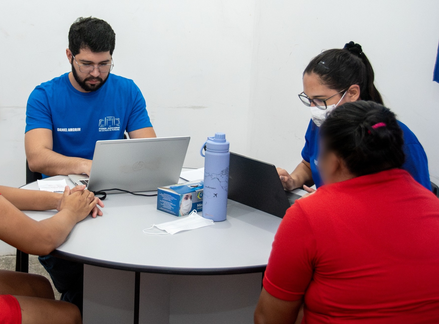 foto colorida de um atendimento com três servidores de tjrr e uma assistido