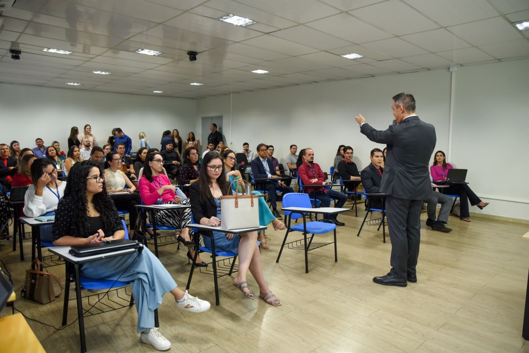 foto colorida de uma turma de servidores sentados em cadeiras escolares 