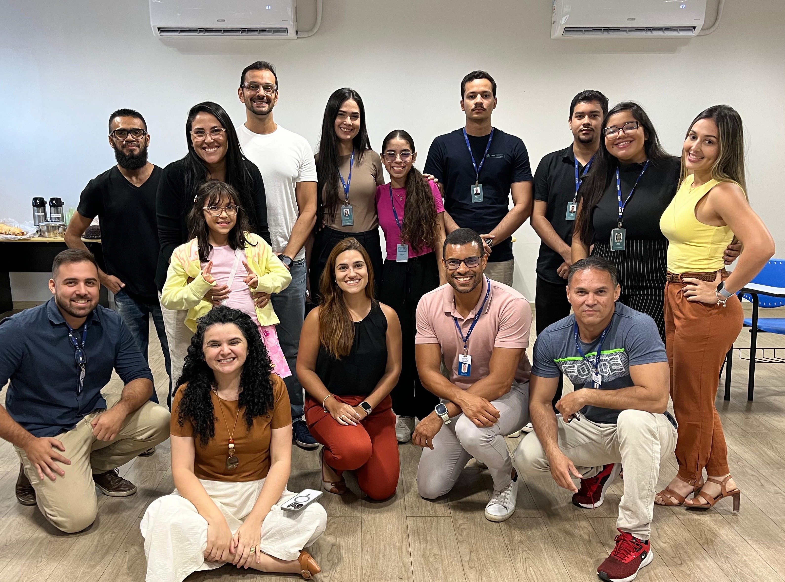 Foto colorida mostrando difente pessoas entre homens, mulheres e crianças posando para foto 