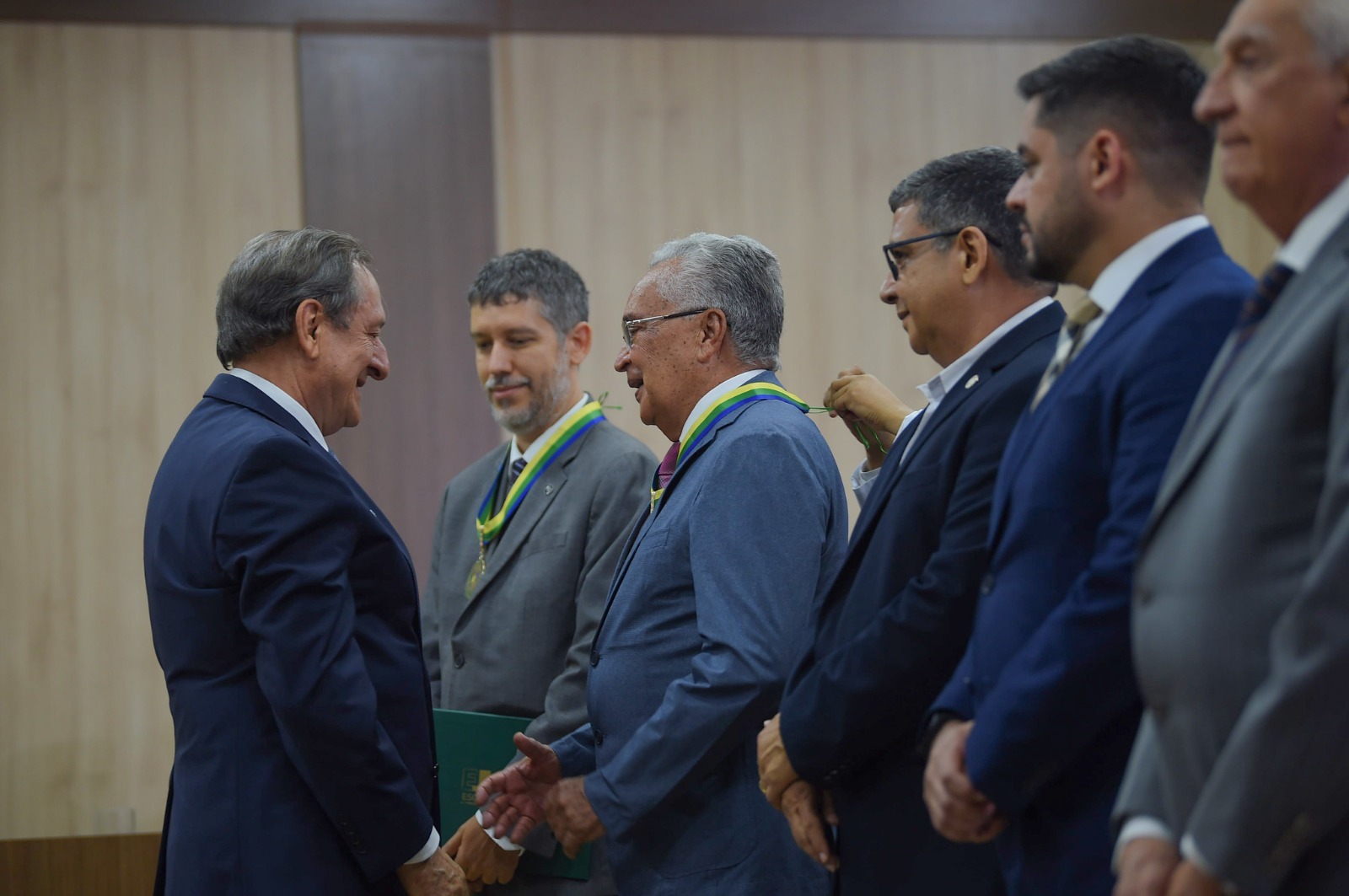 to colorida mostra seis pessoas reunidas durante o recebimento da medalha de honra, no qual na entre eles está o  desembargador Lupercino Nogueira, magistrado aposentado do TJRR, recebendo a Medalha de Mérito Acadêmico da Escola Judicial do Justiça do Amazonas 